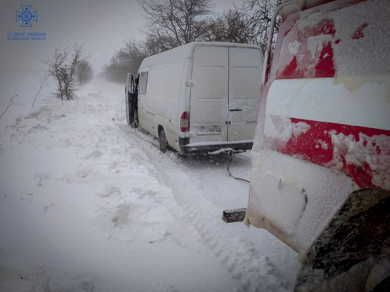 Emergency workers release a van which is stuck in snow during a heavy snow storm in Odesa region