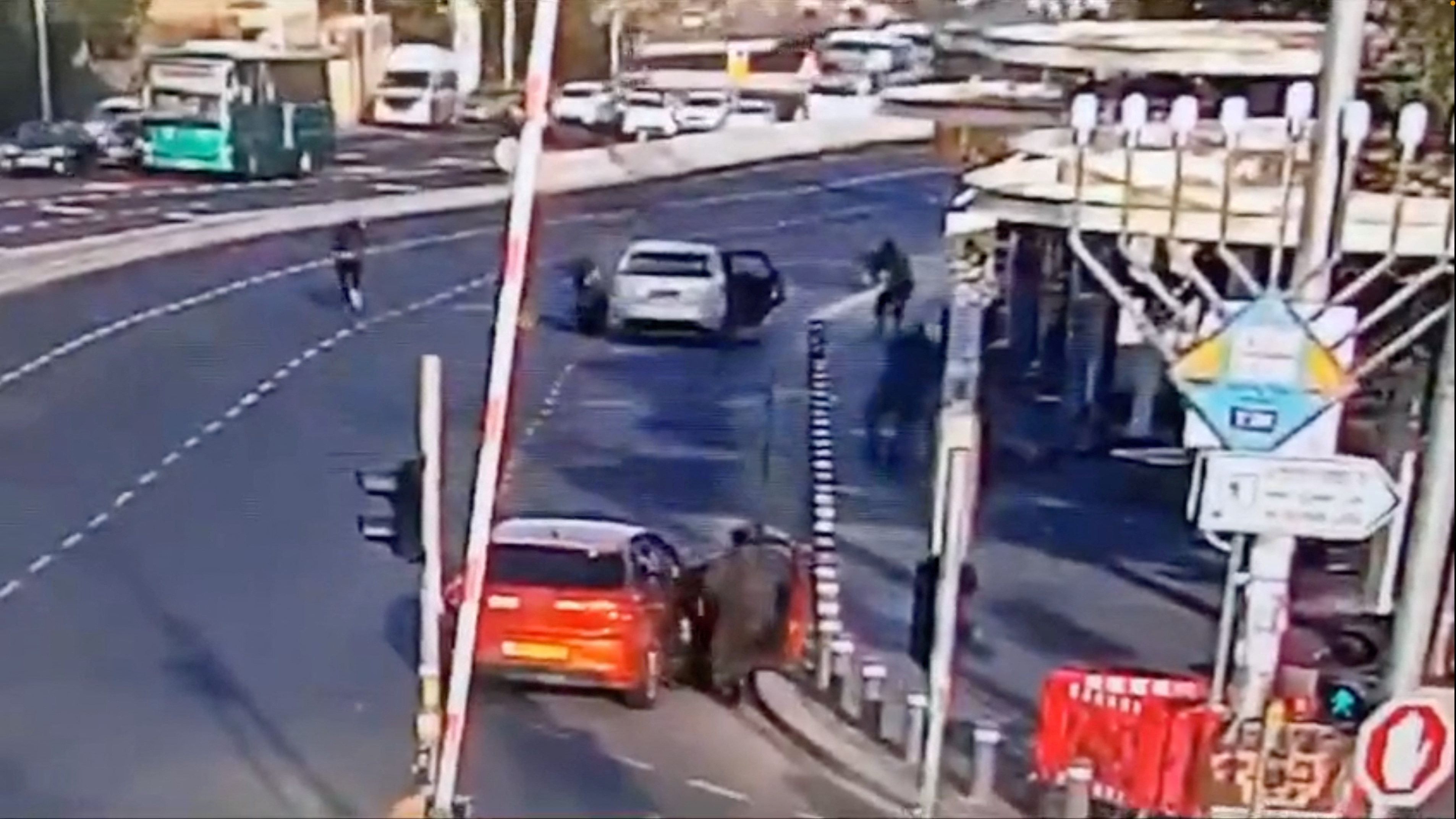 Israeli police take position as two Palestinian attackers take cover after opening fire at a bus stop at the entrance to Jerusalem