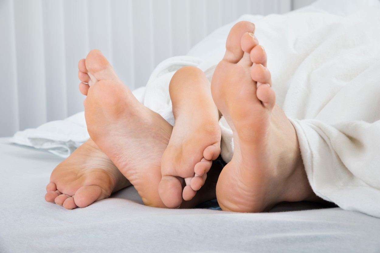 Feet Of Couple In Bed