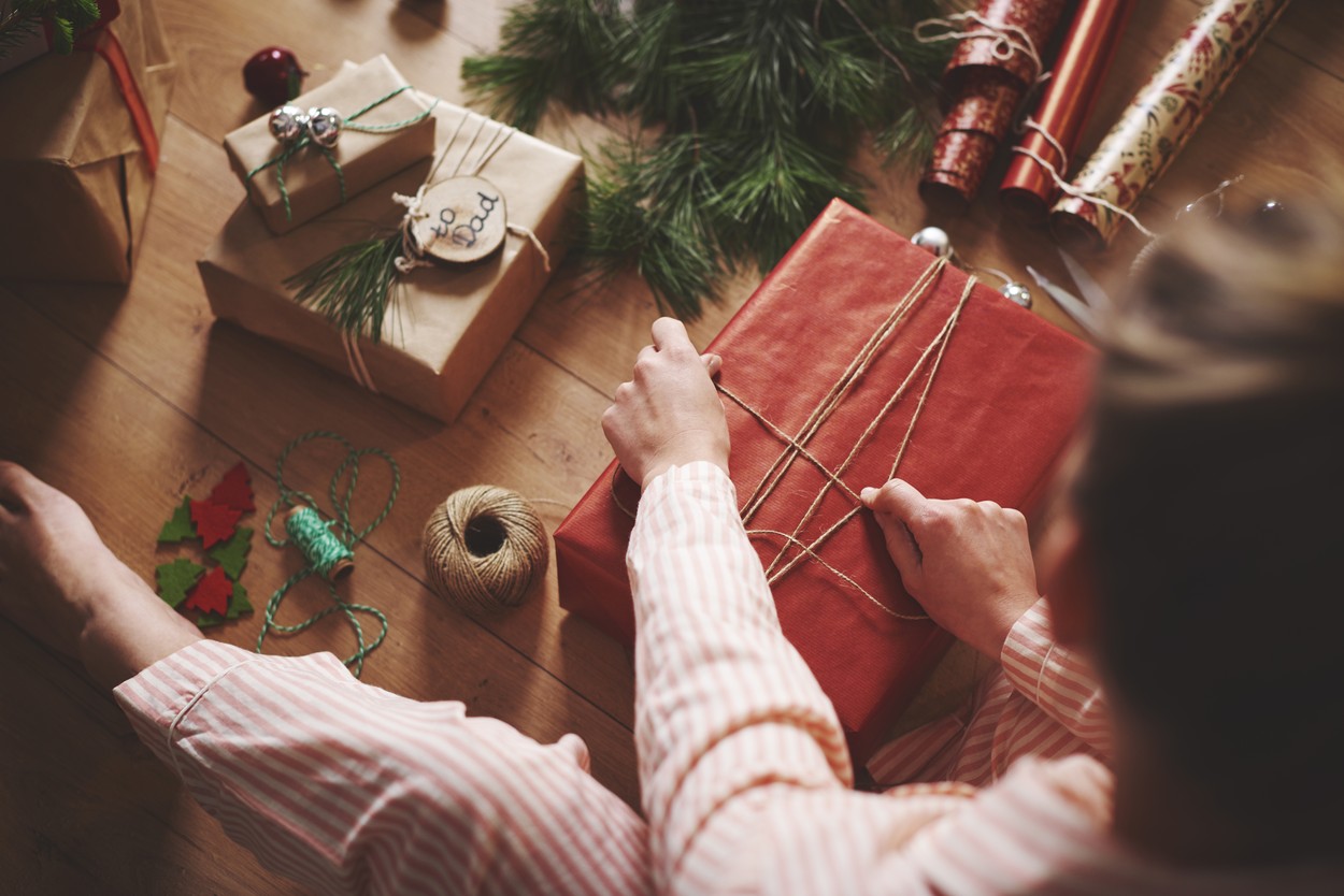 Woman wrapping christmas gift with twine