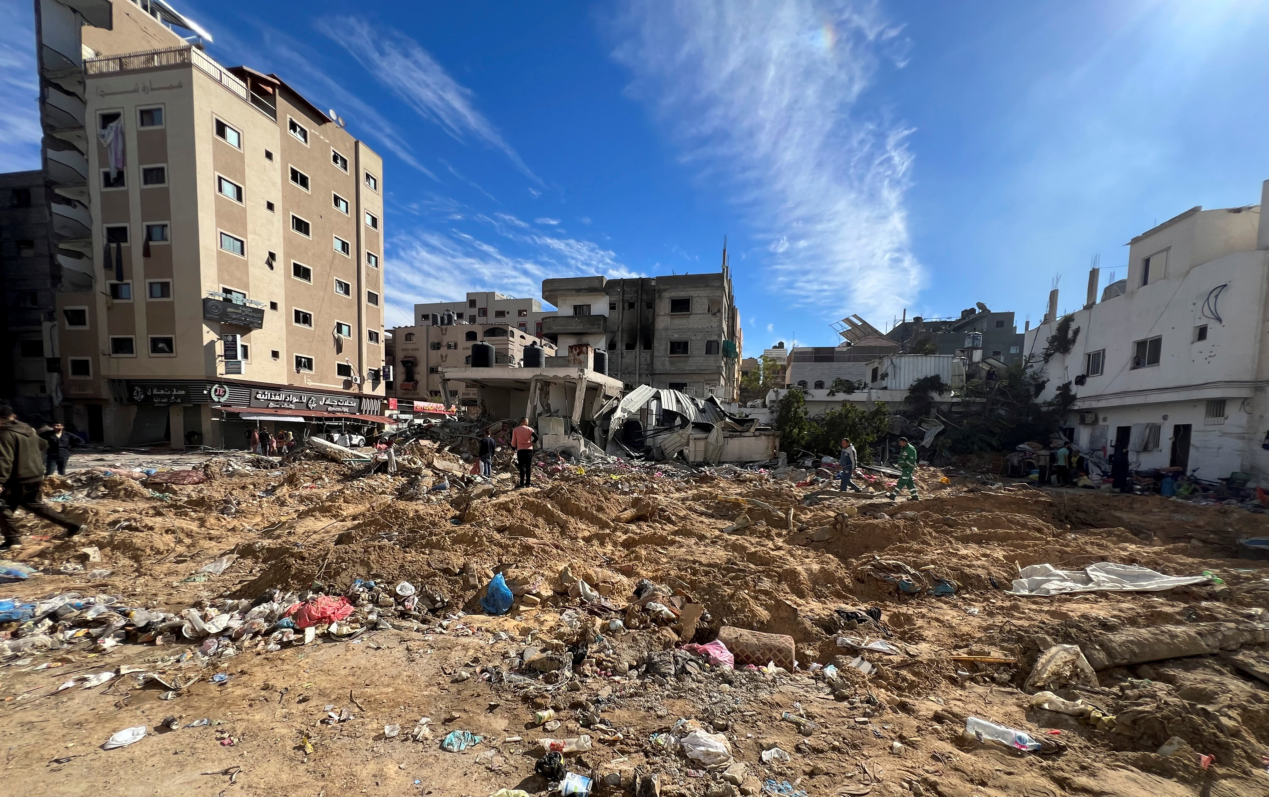 Palestinians inspect damages following an Israeli raid at Kamal Adwan hospital in the northern Gaza Strip