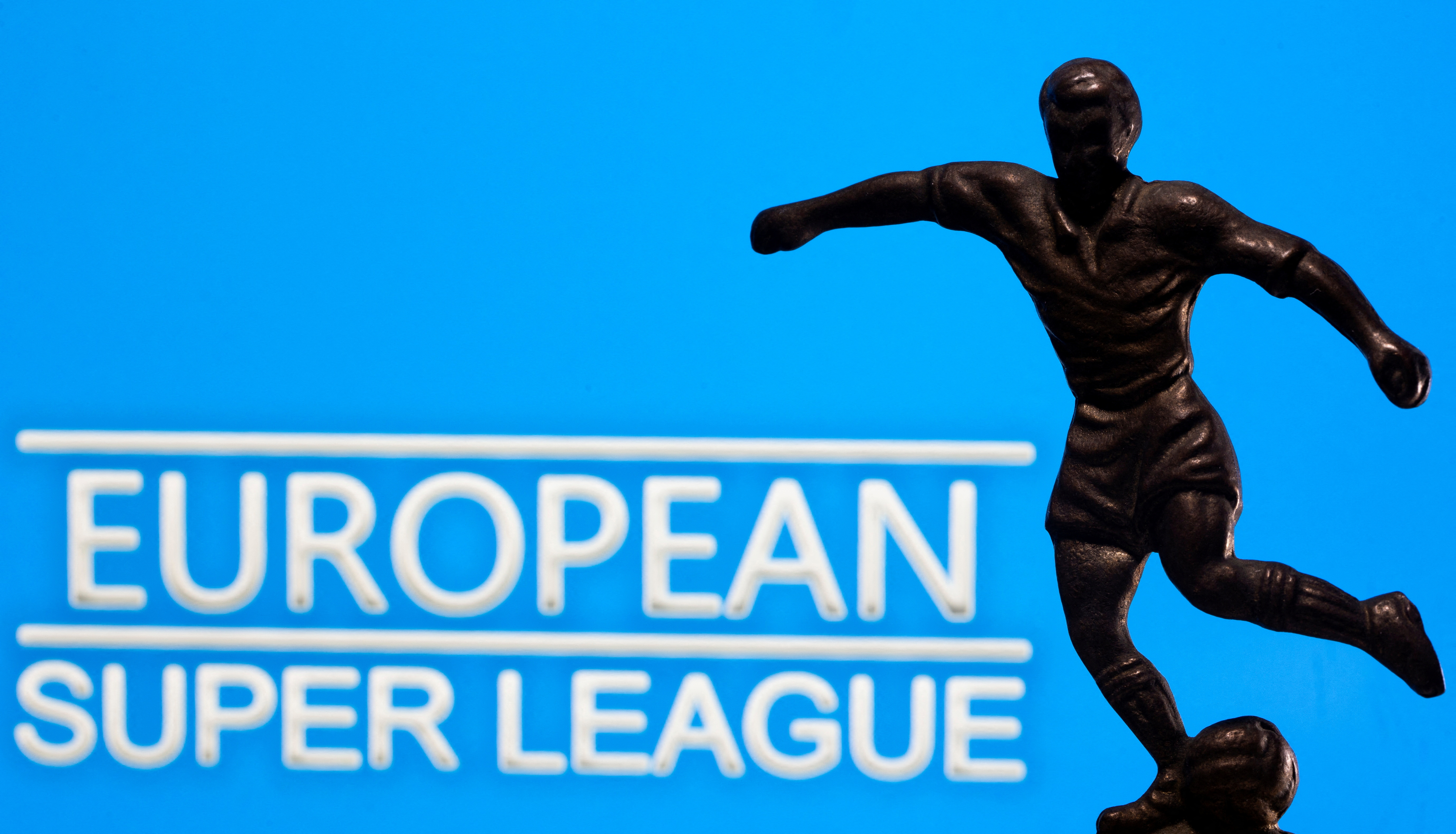 FILE PHOTO: A metal figure of a football player with a ball is seen in front of the words "European Super League" in this illustration
