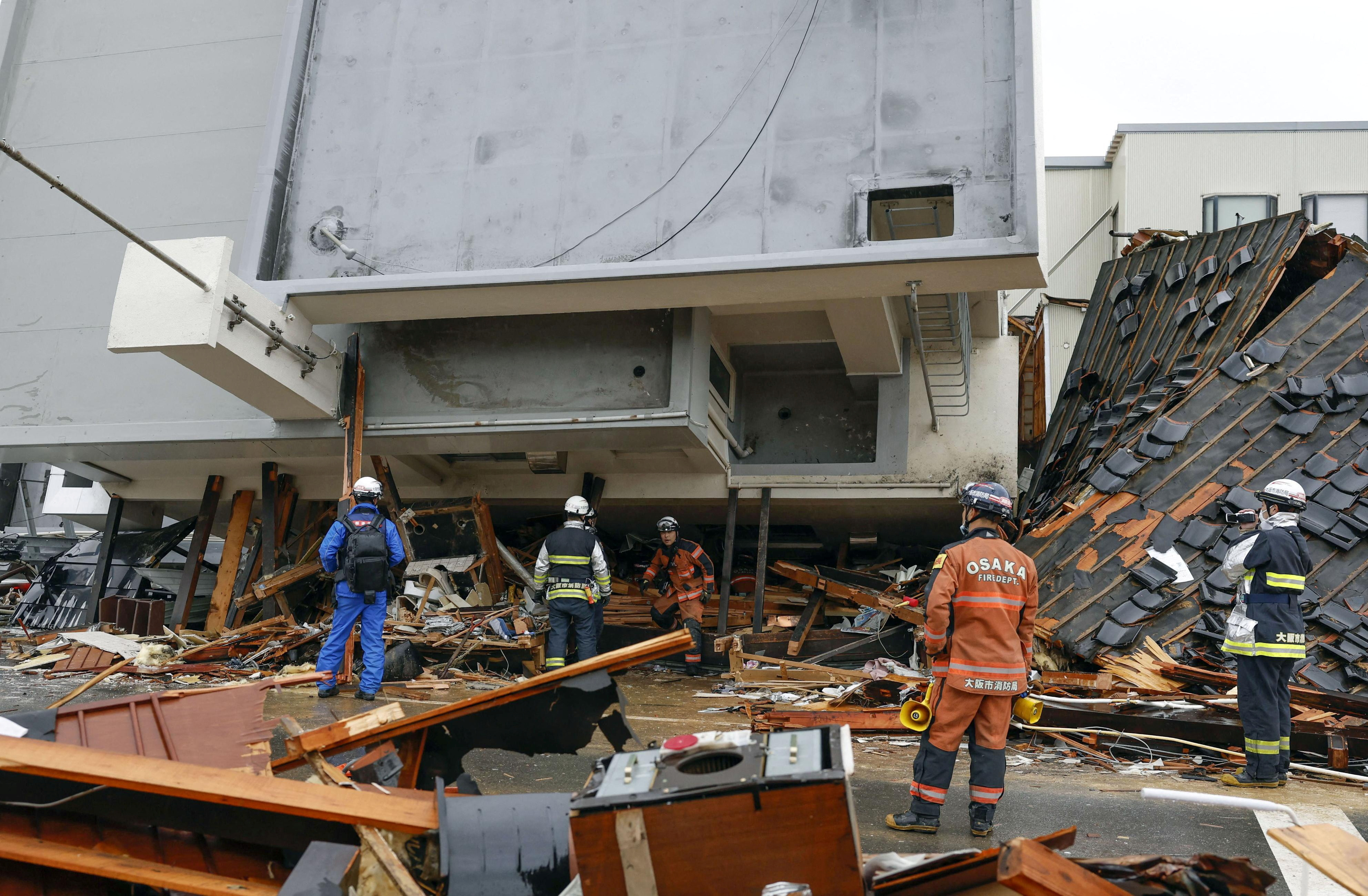 Rescue workers conduct resuce operations at a collapsed building caused by an earthquake in Wajima