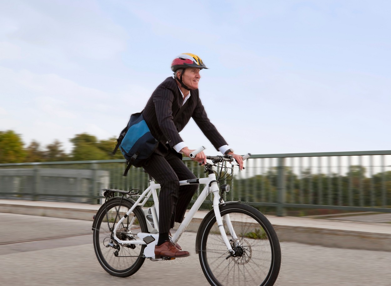 Businessman riding bicycle on bridge