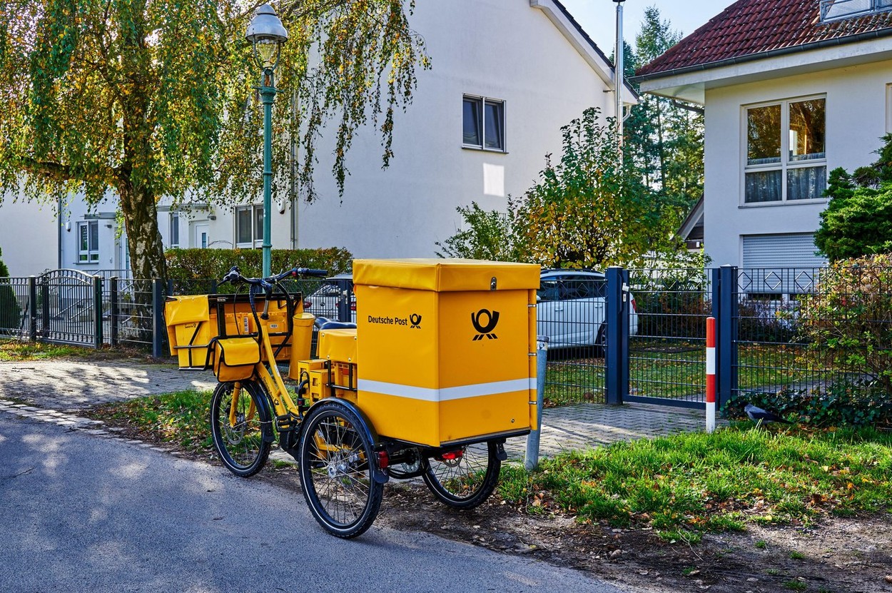Berlin, Germany - October 23, 2021: Electric tricycle from the company Deutsche Post on a street near the urban fringe of Berlin.