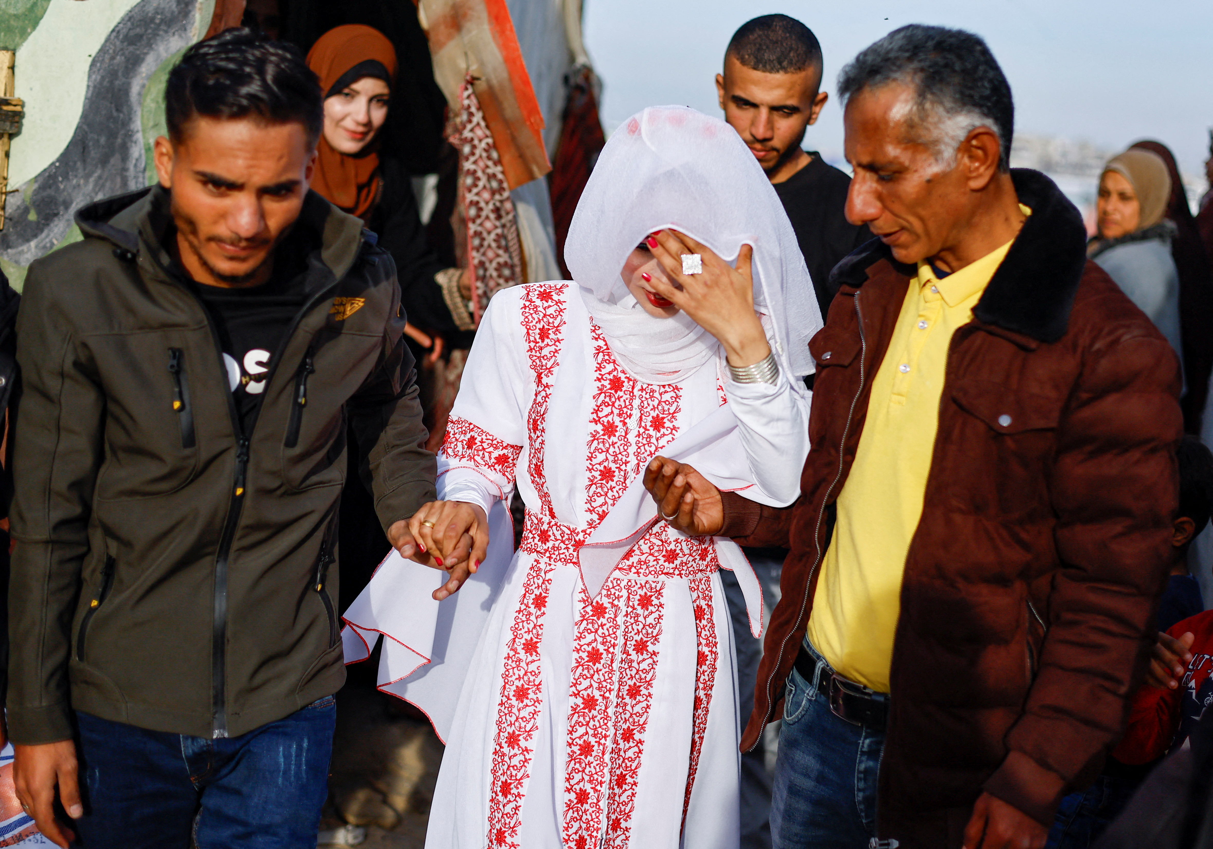 A Palestinian couple walks on their wedding day in the tent camp in Rafah