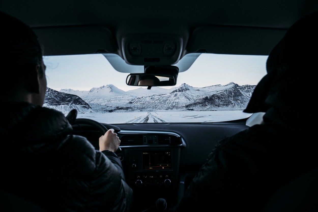 Men driving car through snow covered landscape, Iceland