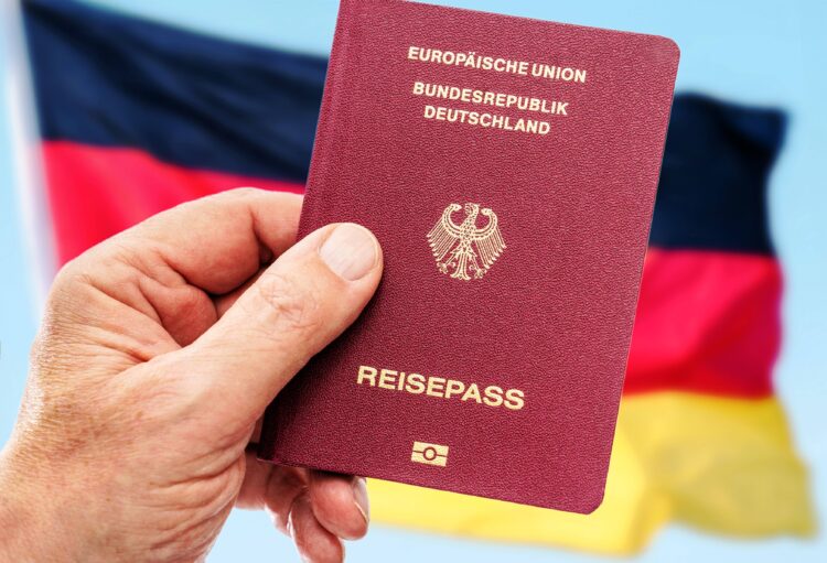 Einbürgerungen werden vereinfacht, Symbolfoto deutscher Reisepass vor Deutschlandfahne, Januar 2024 Deutschland, Berlin,