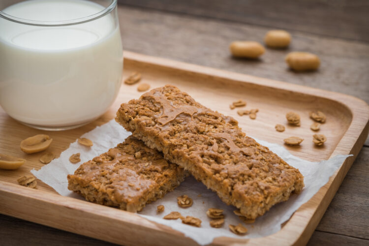 Granola,Bars,And,Glass,Of,Milk,On,Wooden,Plate