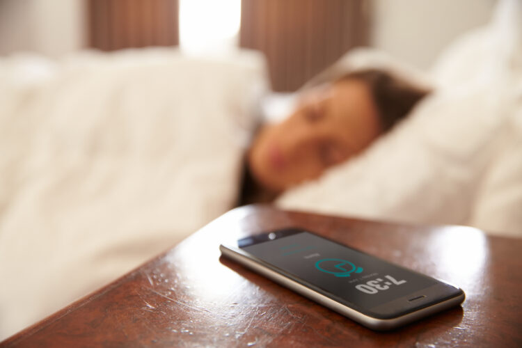 Woman,Asleep,In,Bed,Woken,By,Alarm,On,Mobile,Phone
