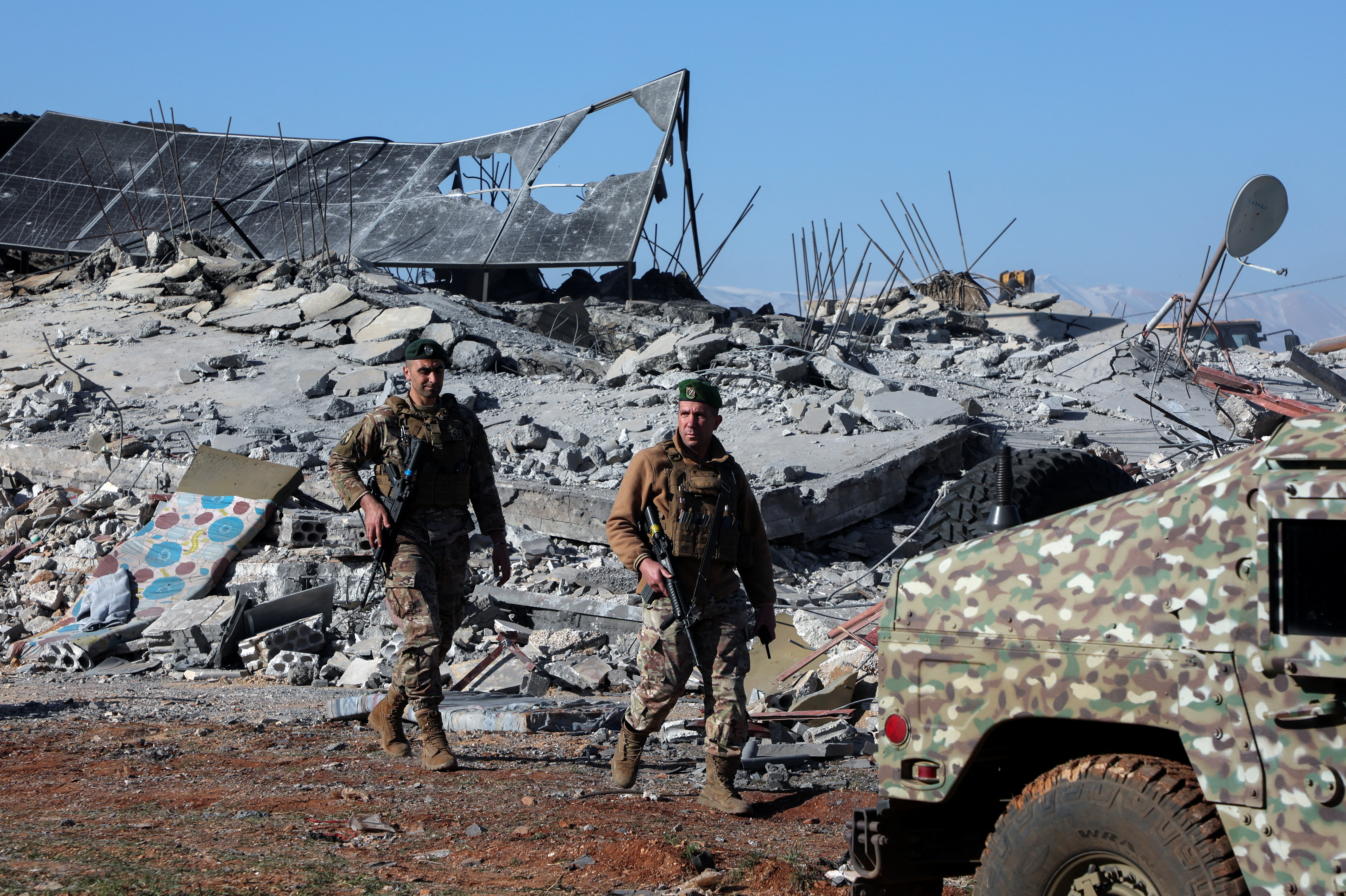 Lebanese army soldiers secure a site that was hit by a strike, in Saraain