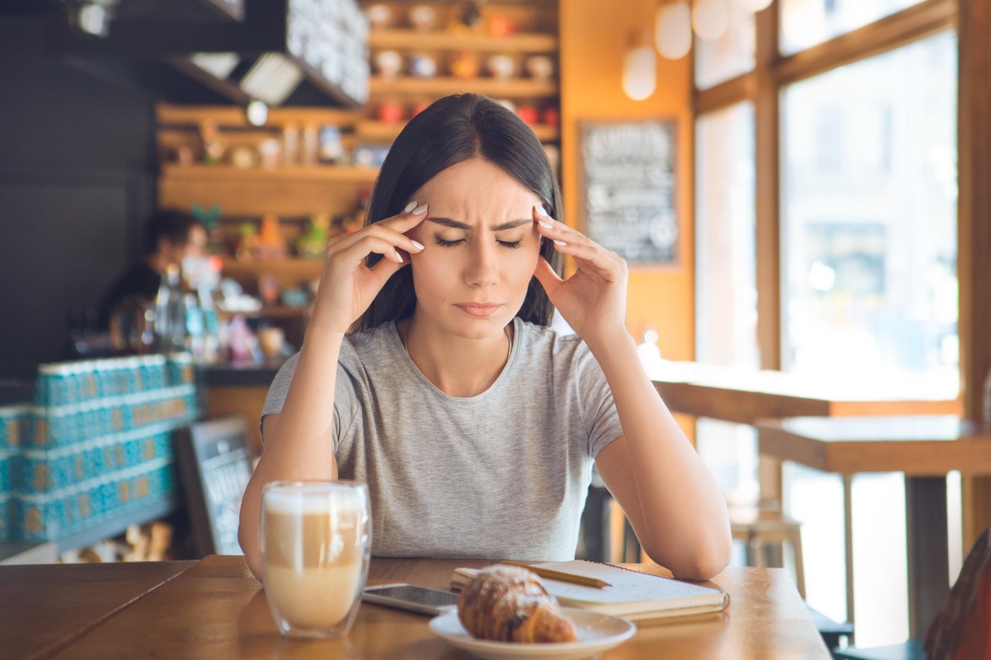 Young female sitting in a cafe indoors rest sick