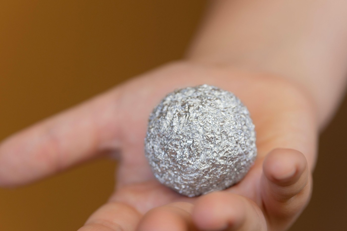 Young Boy Holding a Aluminium Foil in the Shape of a Sphere