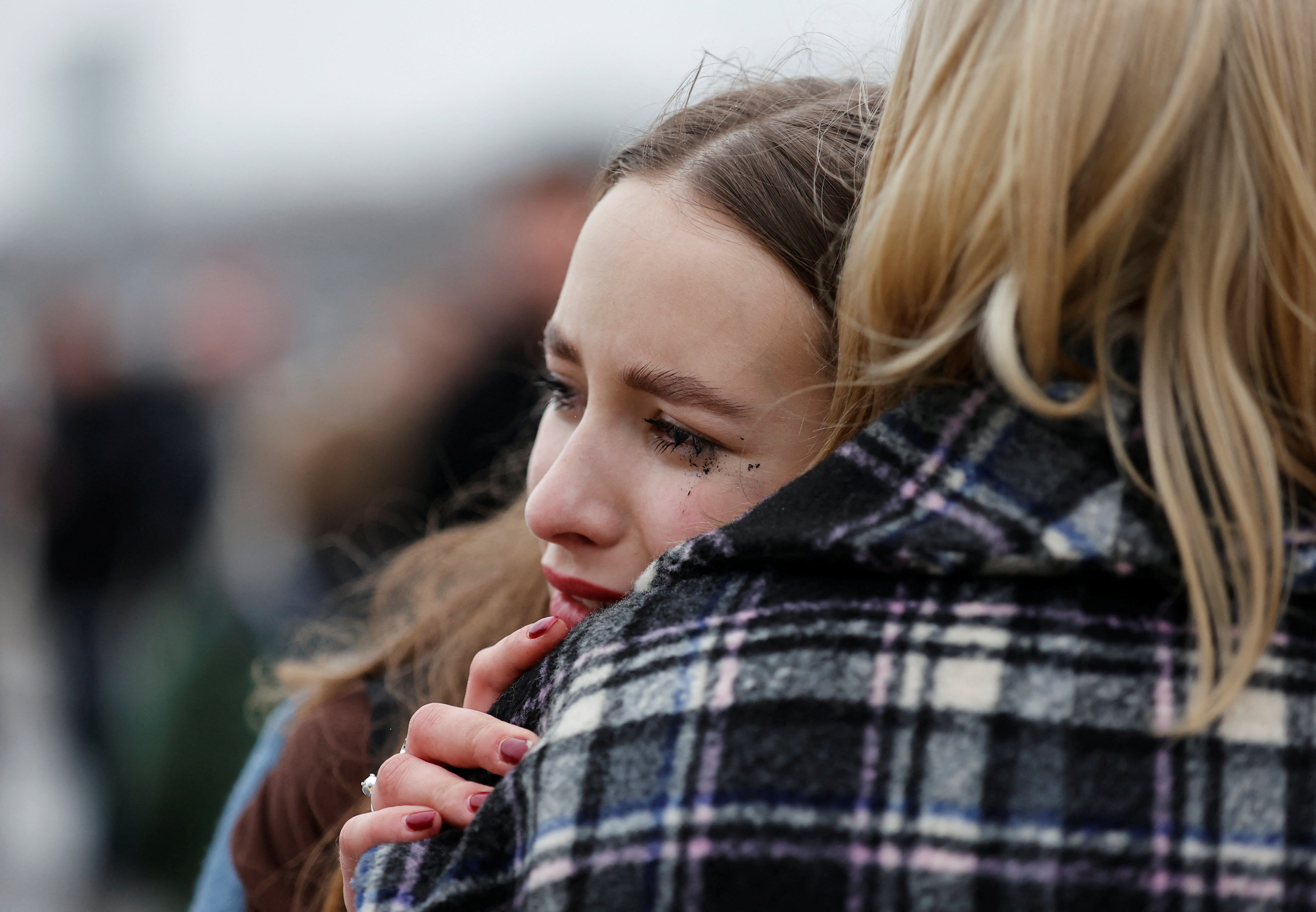 People lay flowers at a makeshift memorial to the victims of a shooting attack at a concert hall outside Moscow