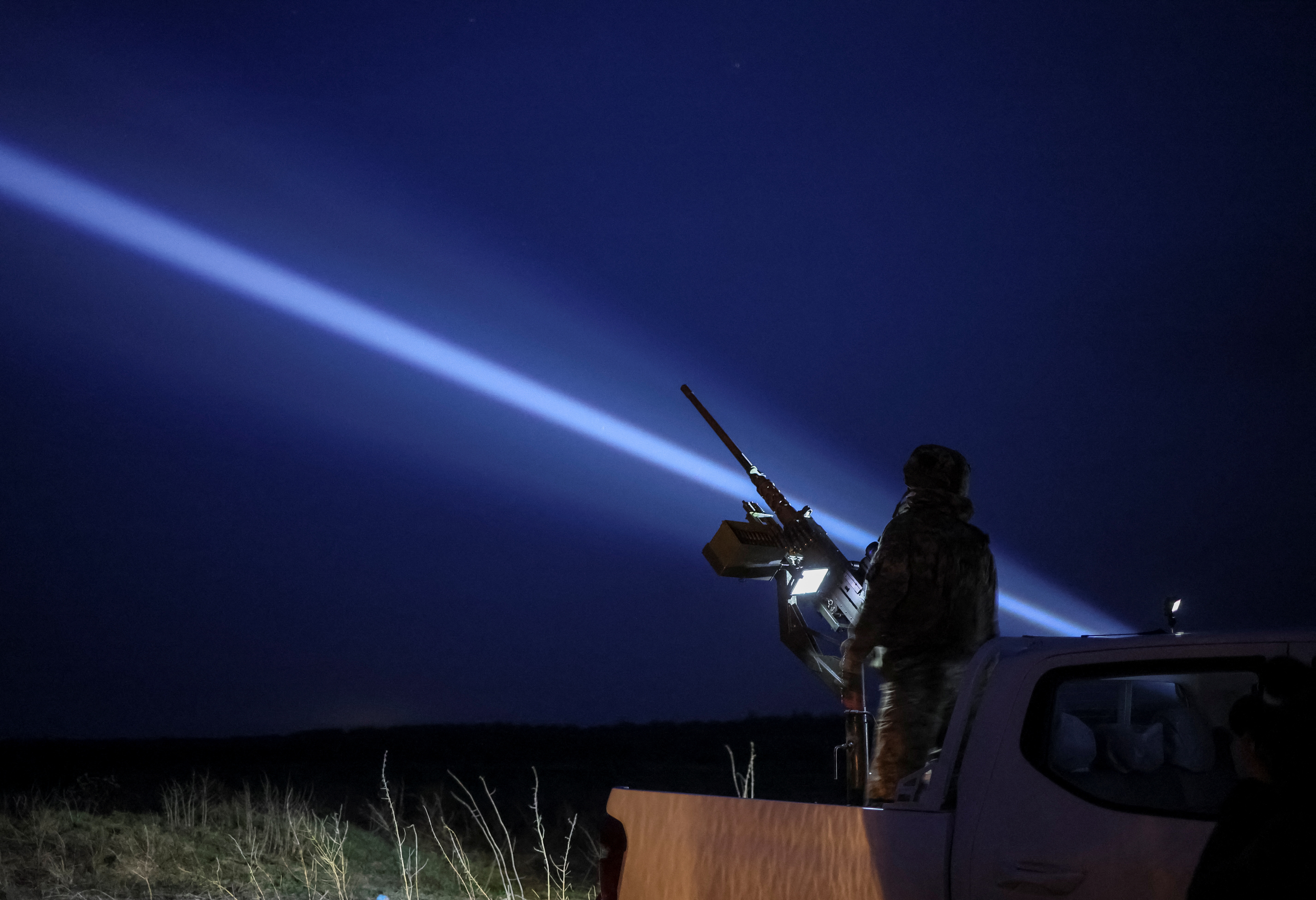 A Ukrainian serviceman from anti-drone mobile air defence unit operates a Browning machine gun at his position in Chernihiv region