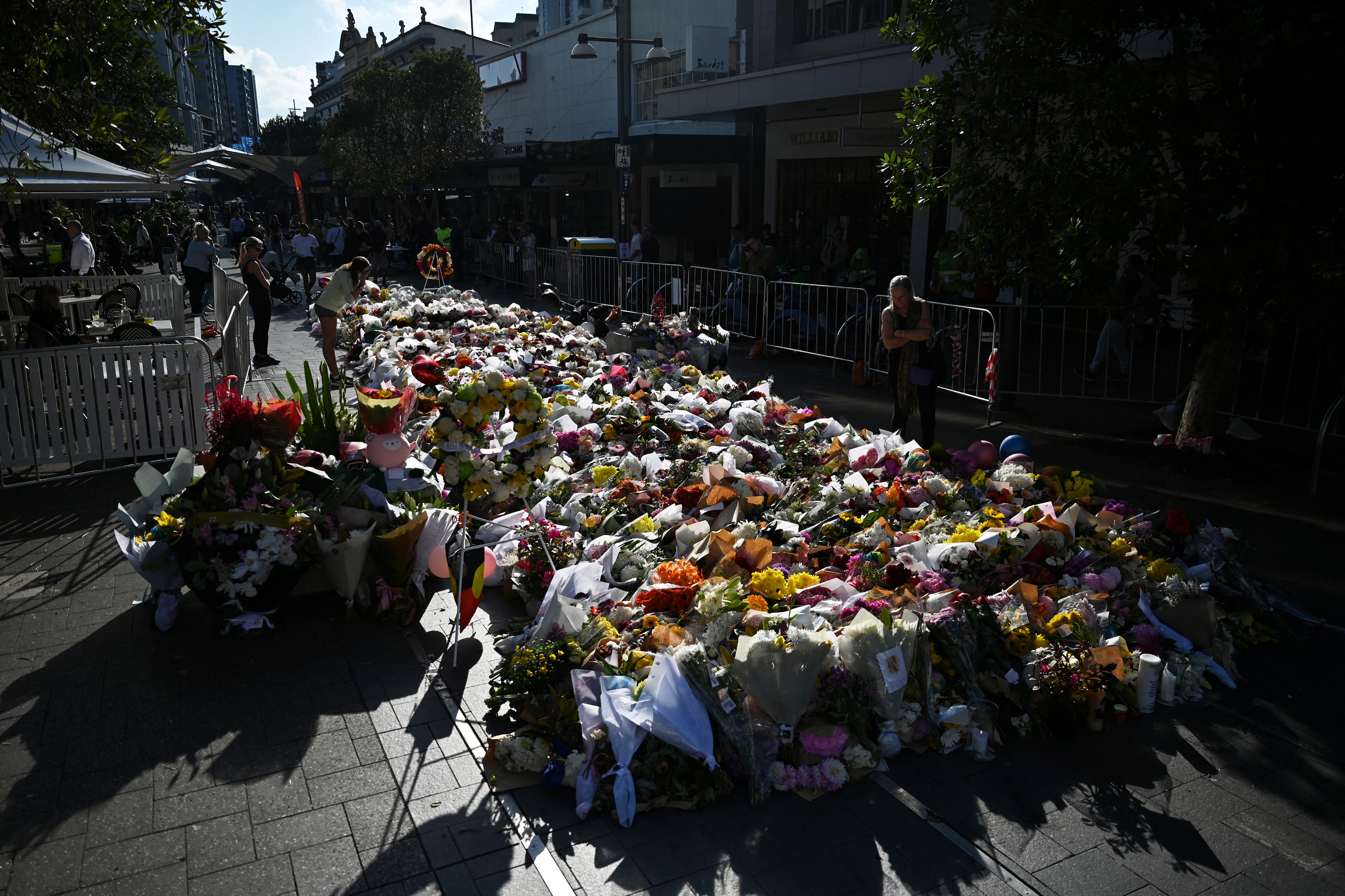People leave floral tributes for victims of the attack at Westfield Bondi Junction shopping centre in Sydney
