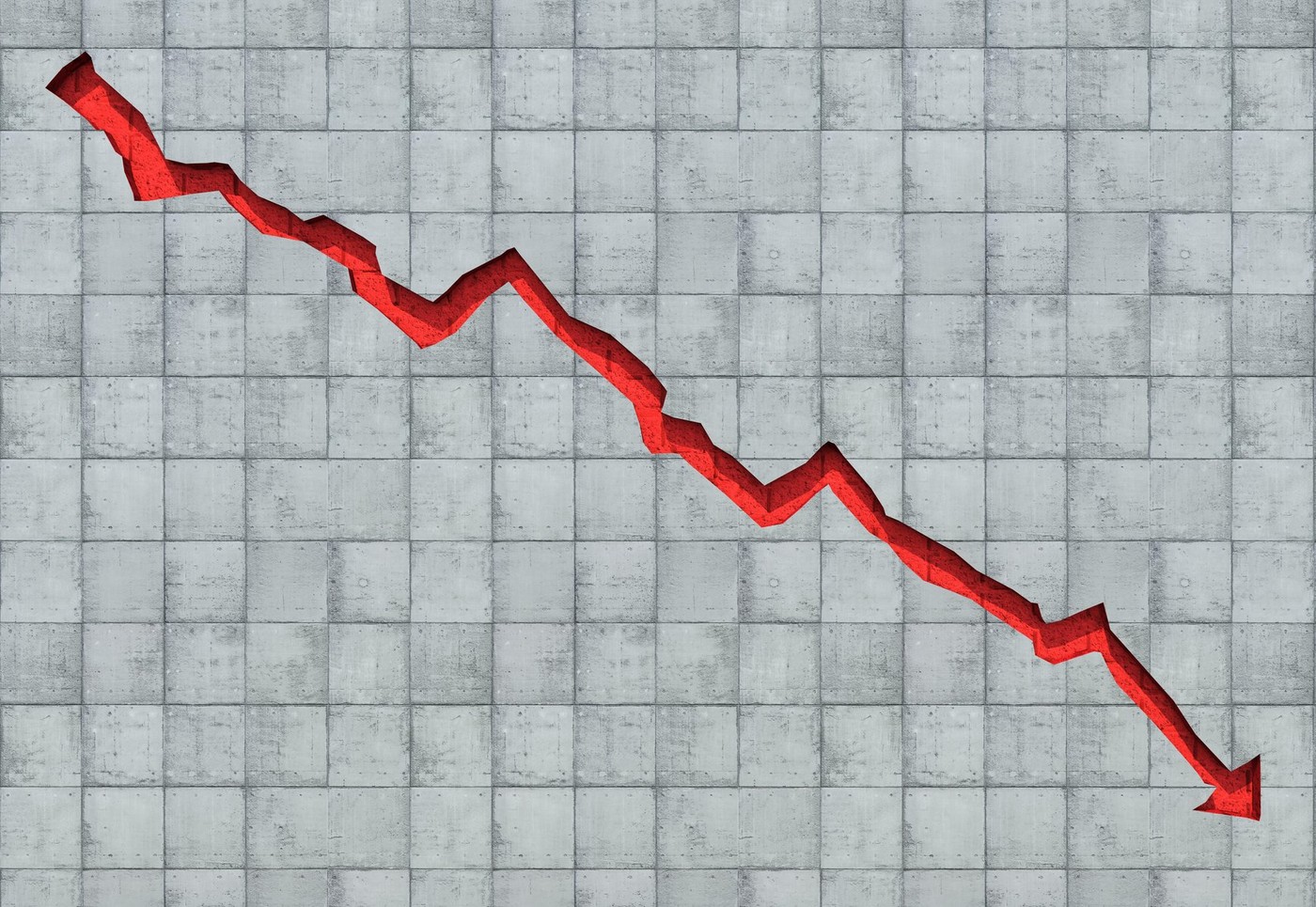 Arrow carved out in concrete wall showing economic decline