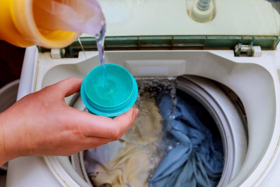 Woman hand pouring washing powder into the washing machine washing powder into the washing machine