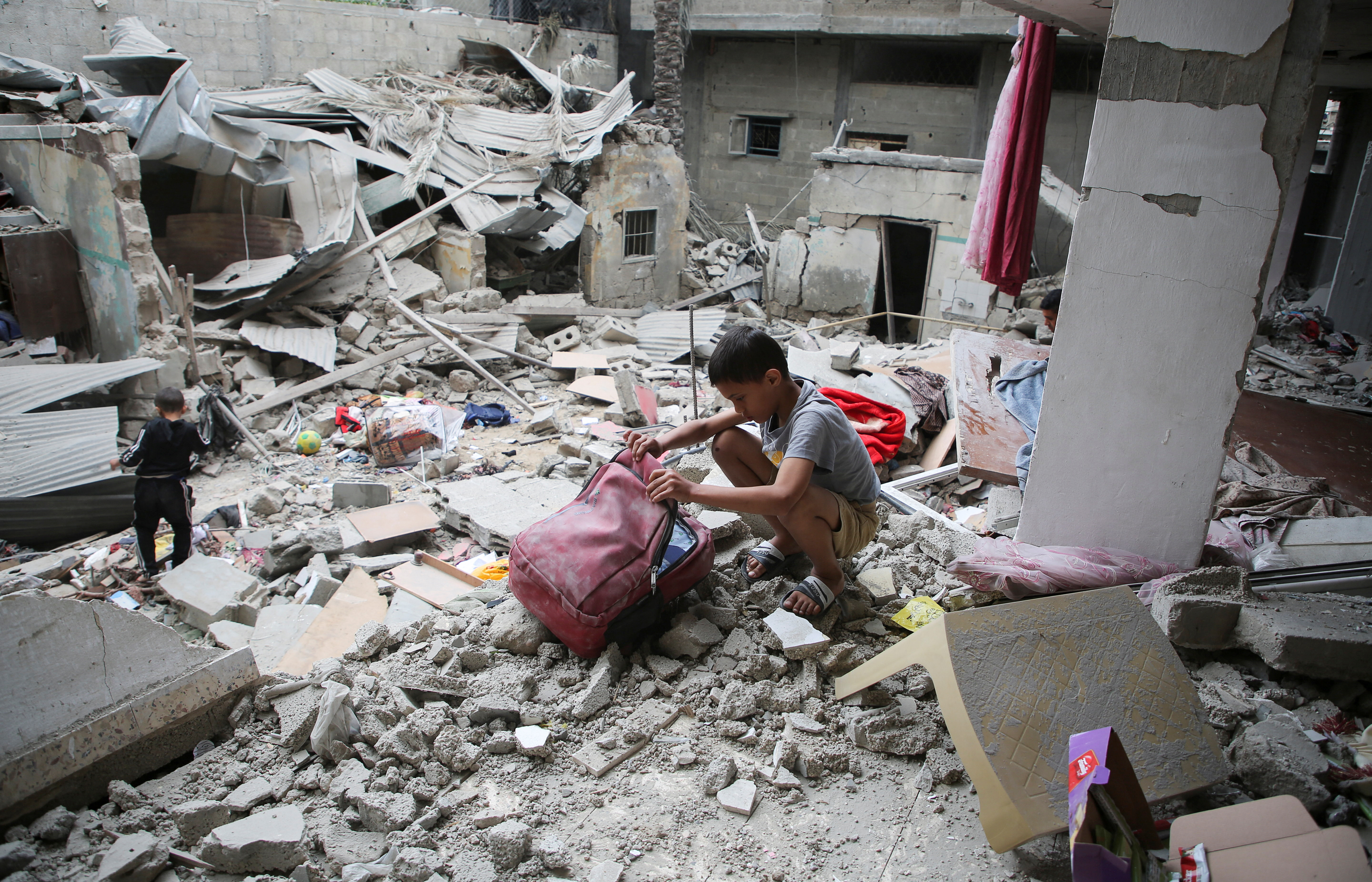Palestinian children inspect the site of an Israeli strike on a house, in Rafah