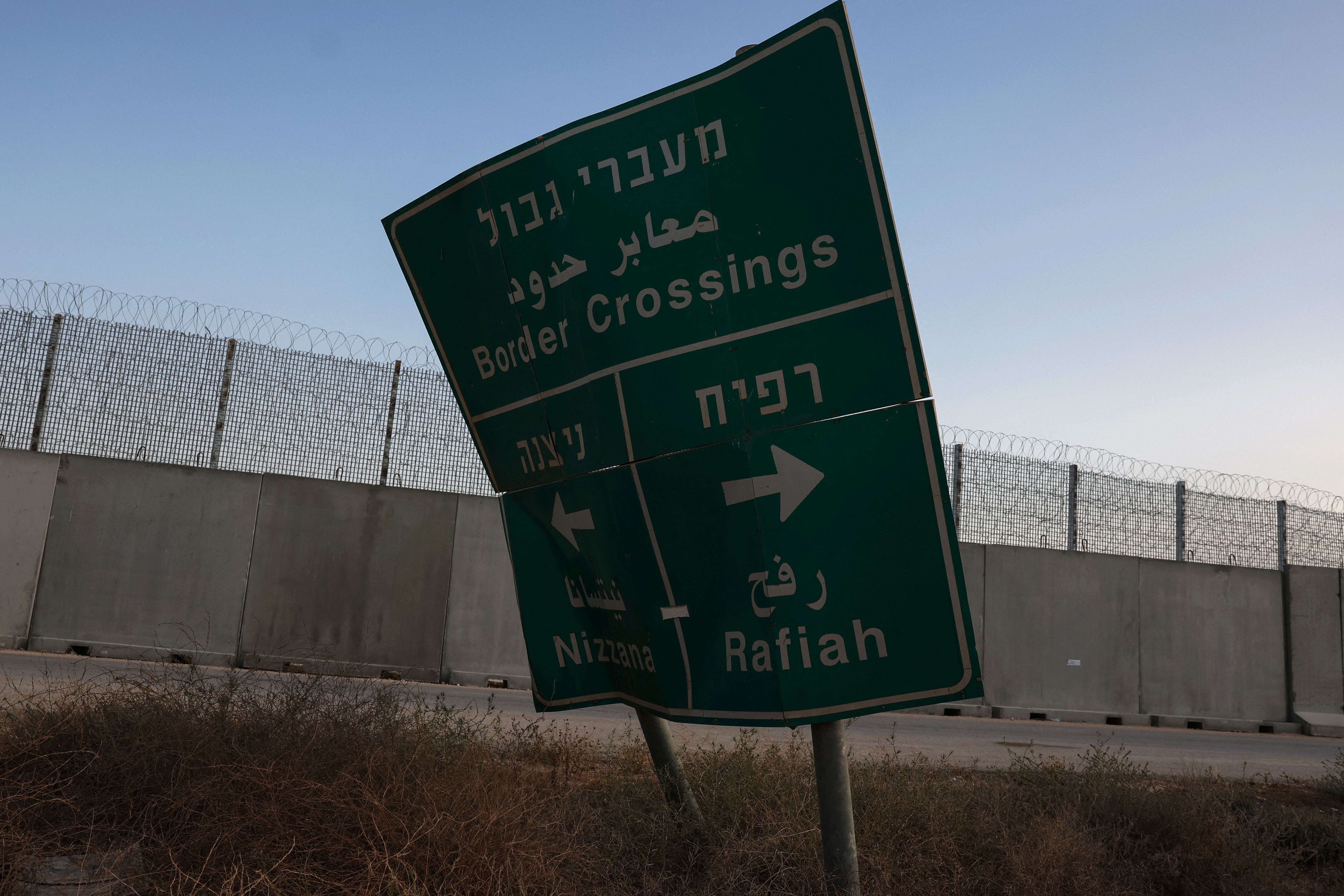 A damaged road sign stands at the Kerem Shalom border crossing, as military operations continue in the southern Gaza city of Rafah, at an area outside Kerem Shalom