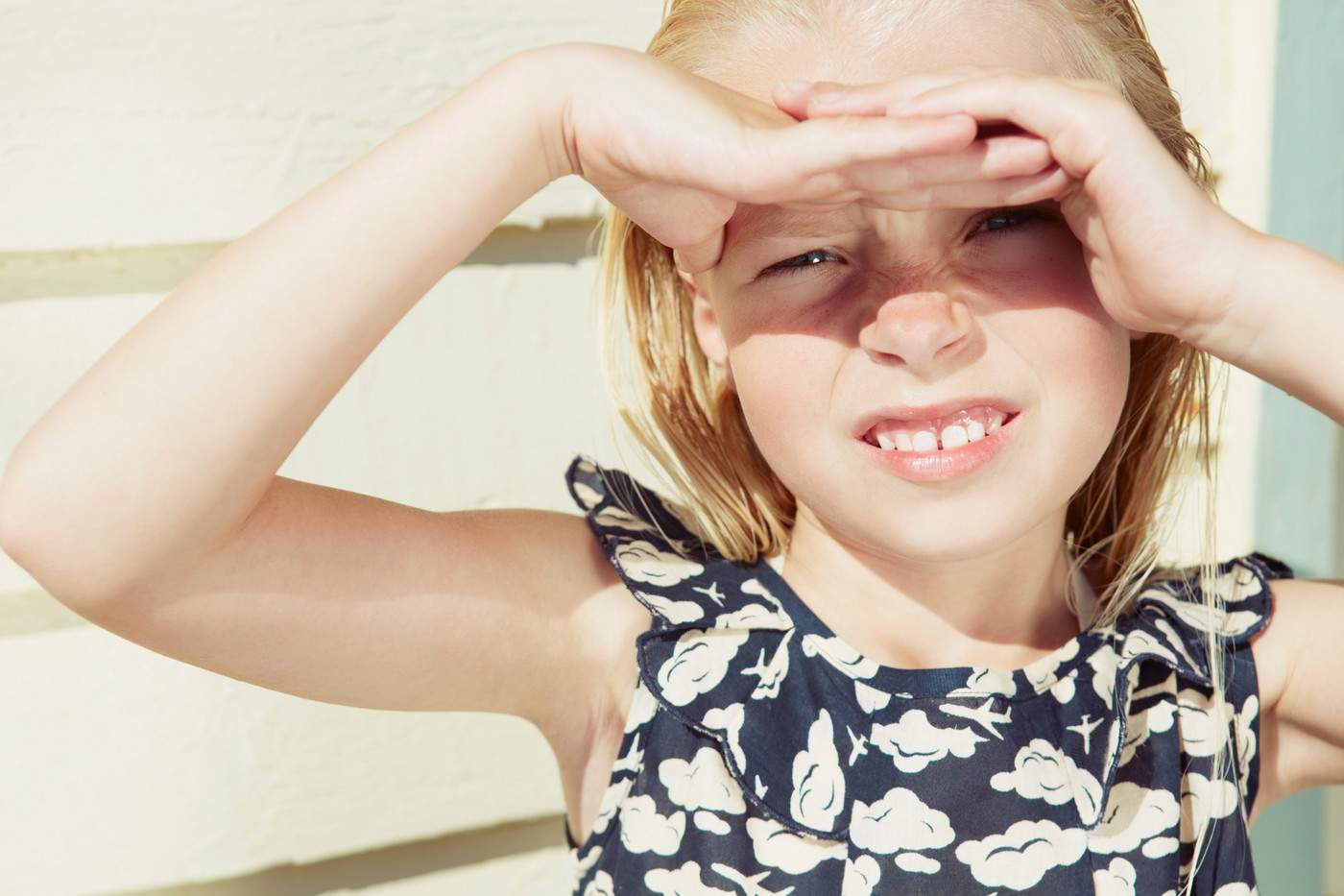 Child covering her eyes from sun glare