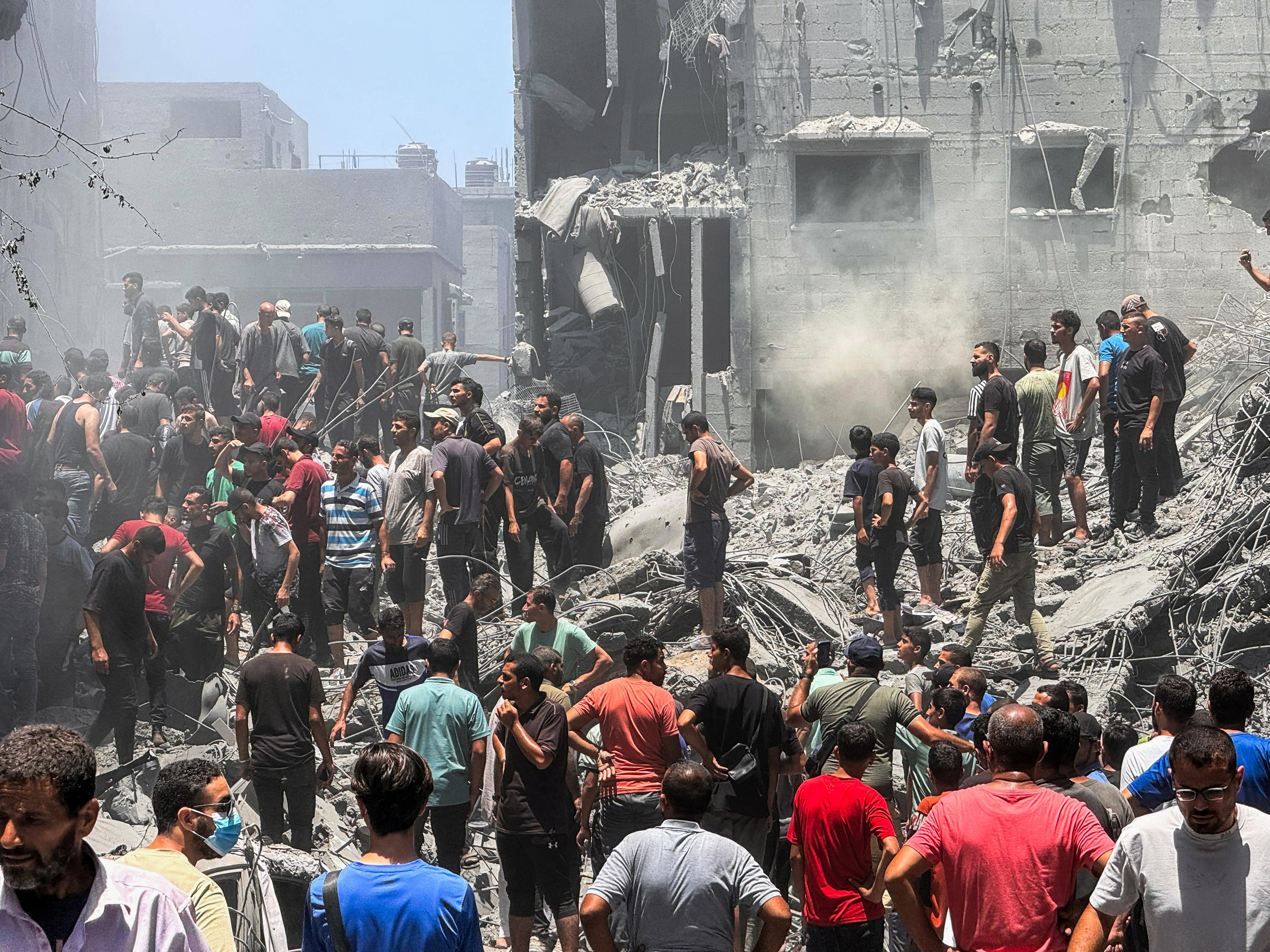 Palestinians search for casualties at the site of Israeli strikes on houses