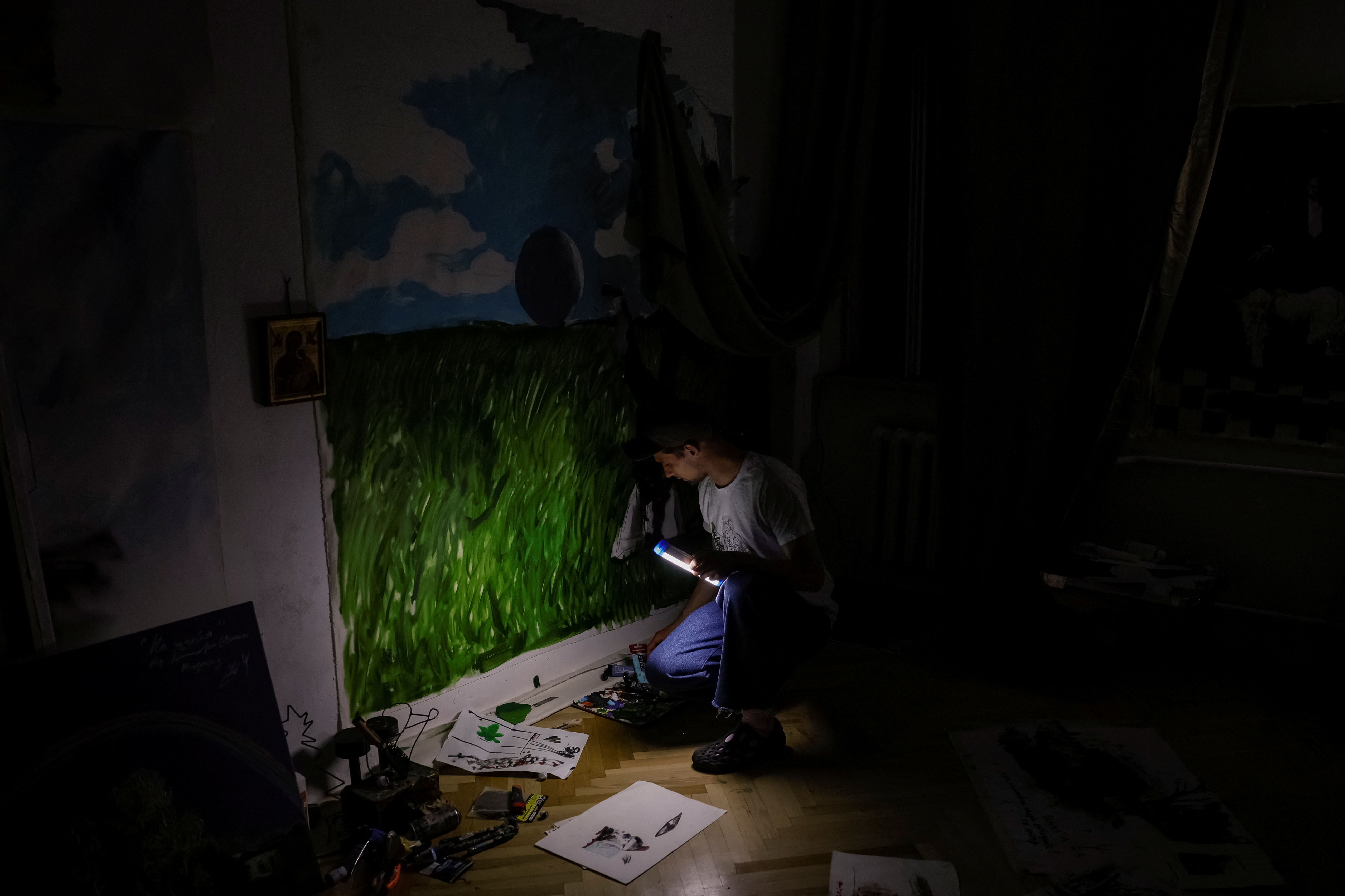 Ukrainian artist works in his apartment during blackout in Kyiv