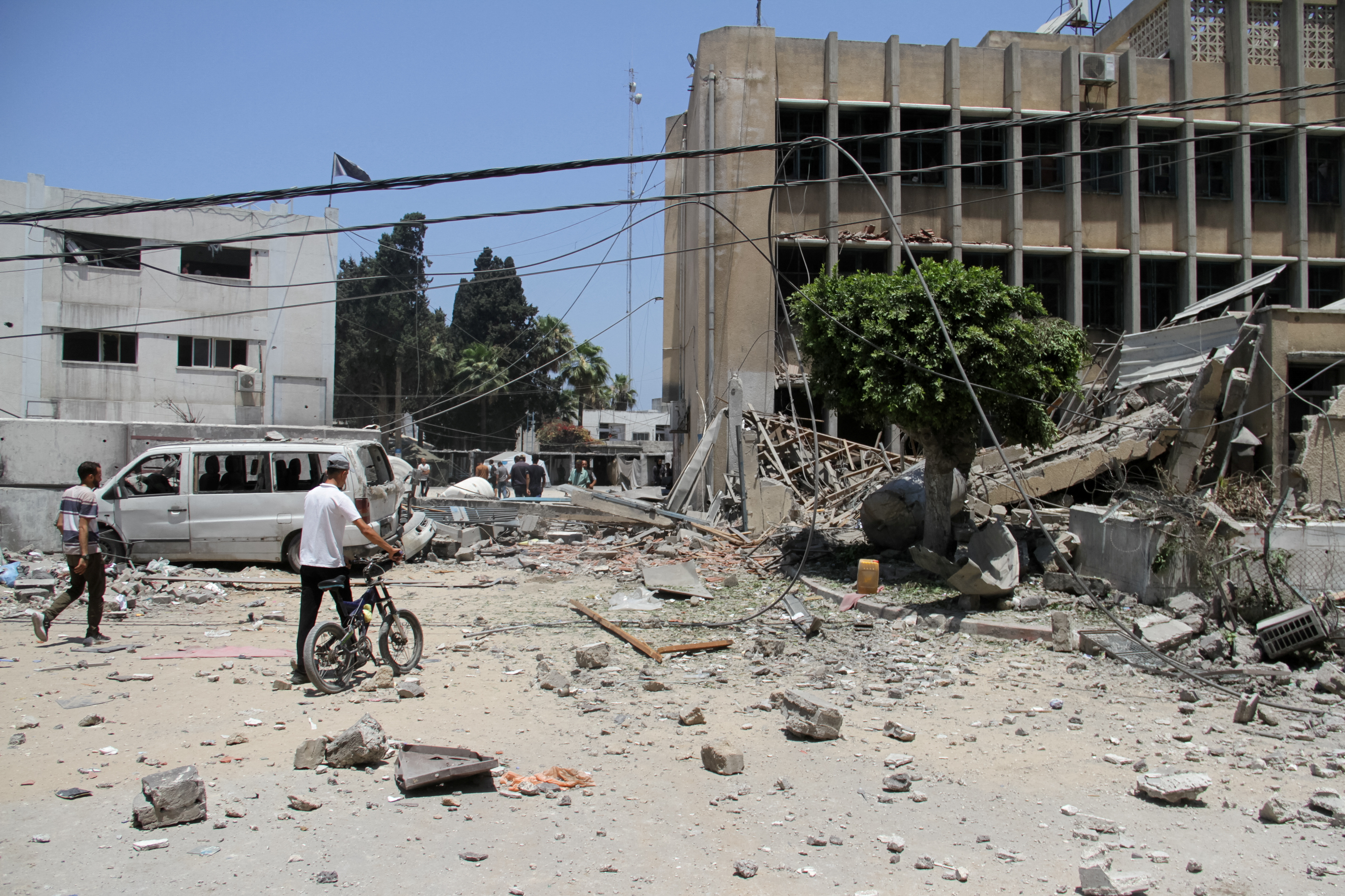 Palestinians search for casualties outside UNRWA headquarters, following an Israeli strike, in Gaza City