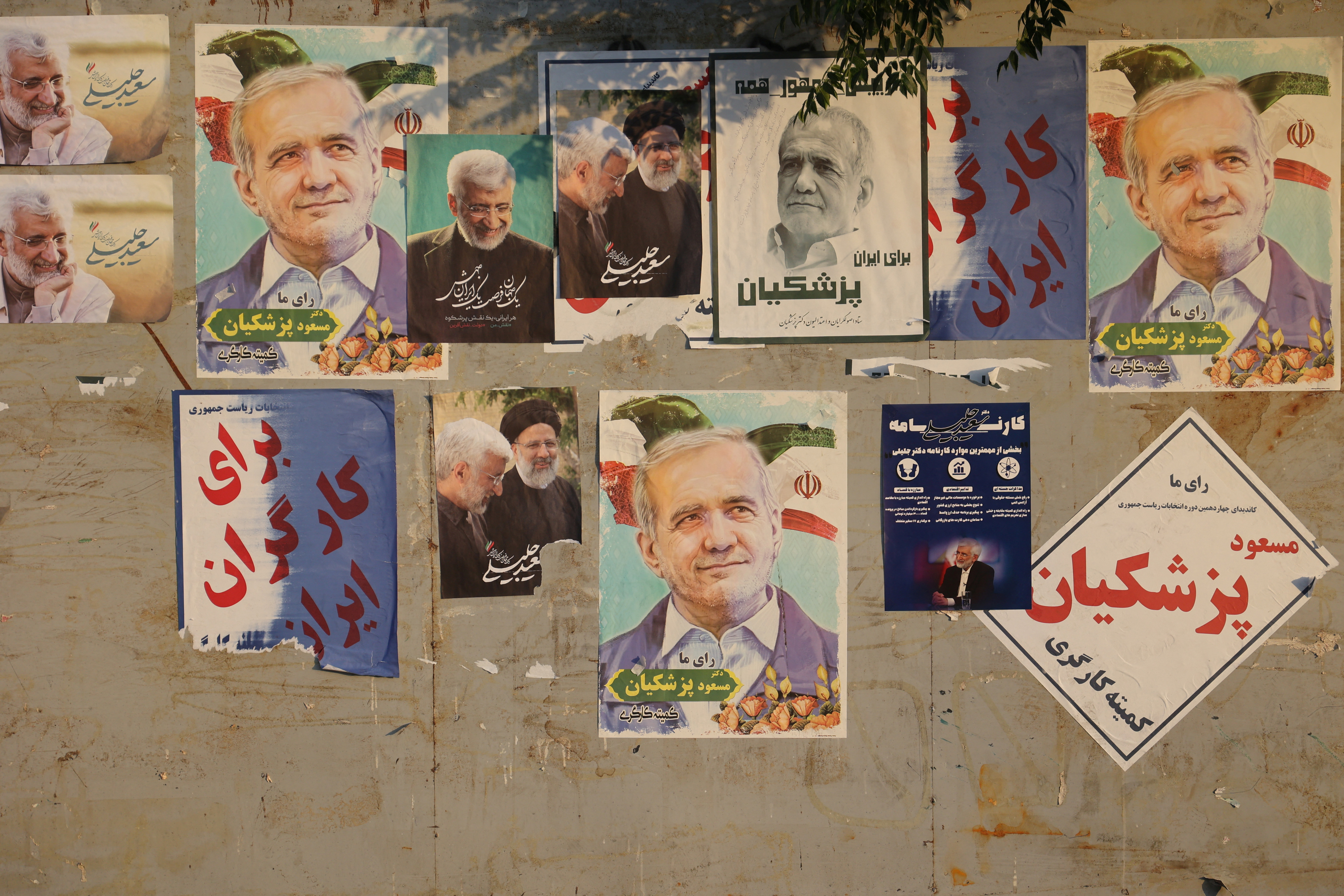 Posters of presidential candidates Masoud Pezeshkian and Saeed Jalili are displayed in a street in Tehran