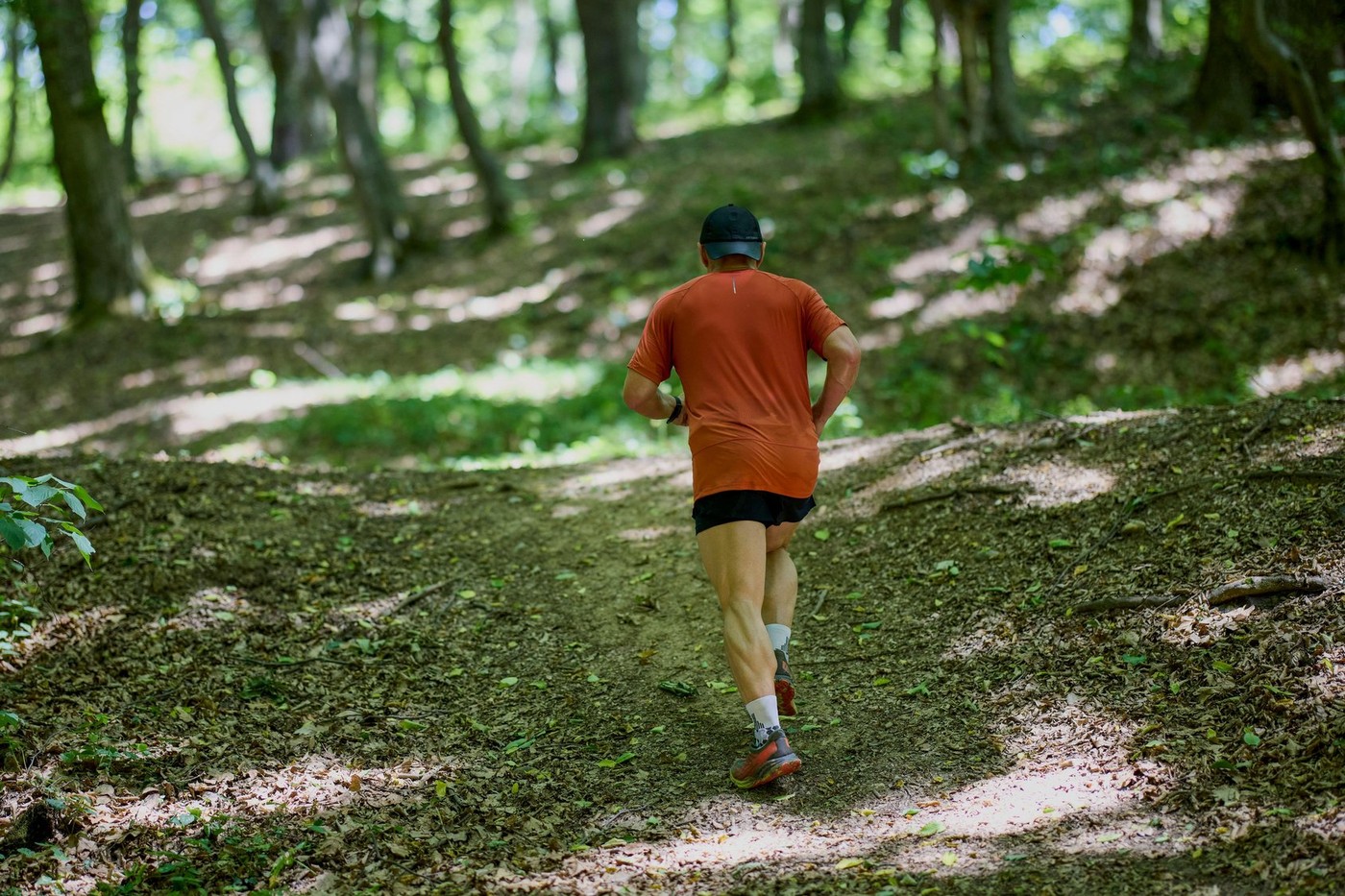 a strong middle-aged man running through the forest