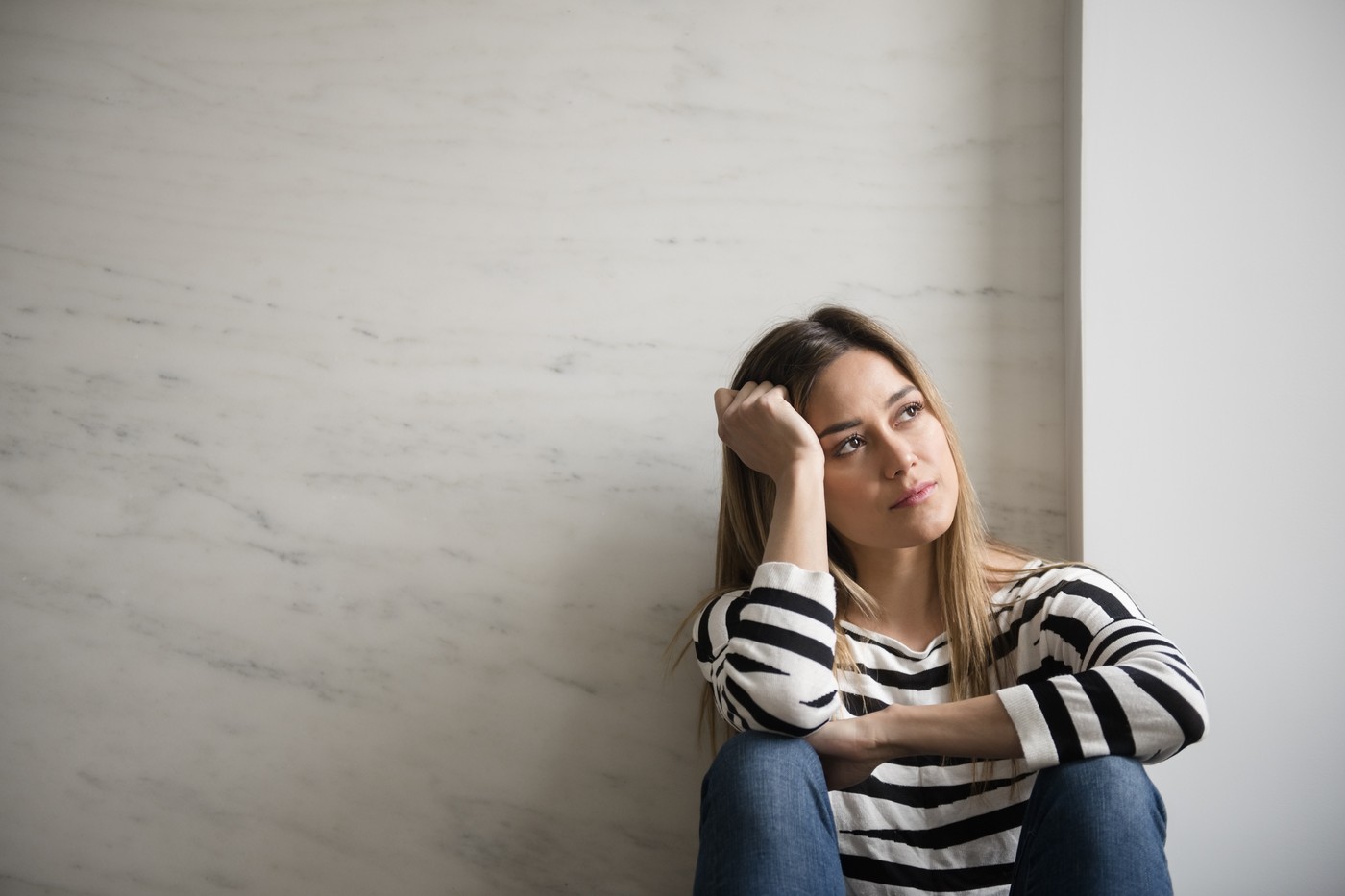 Young woman wearing striped top daydreaming