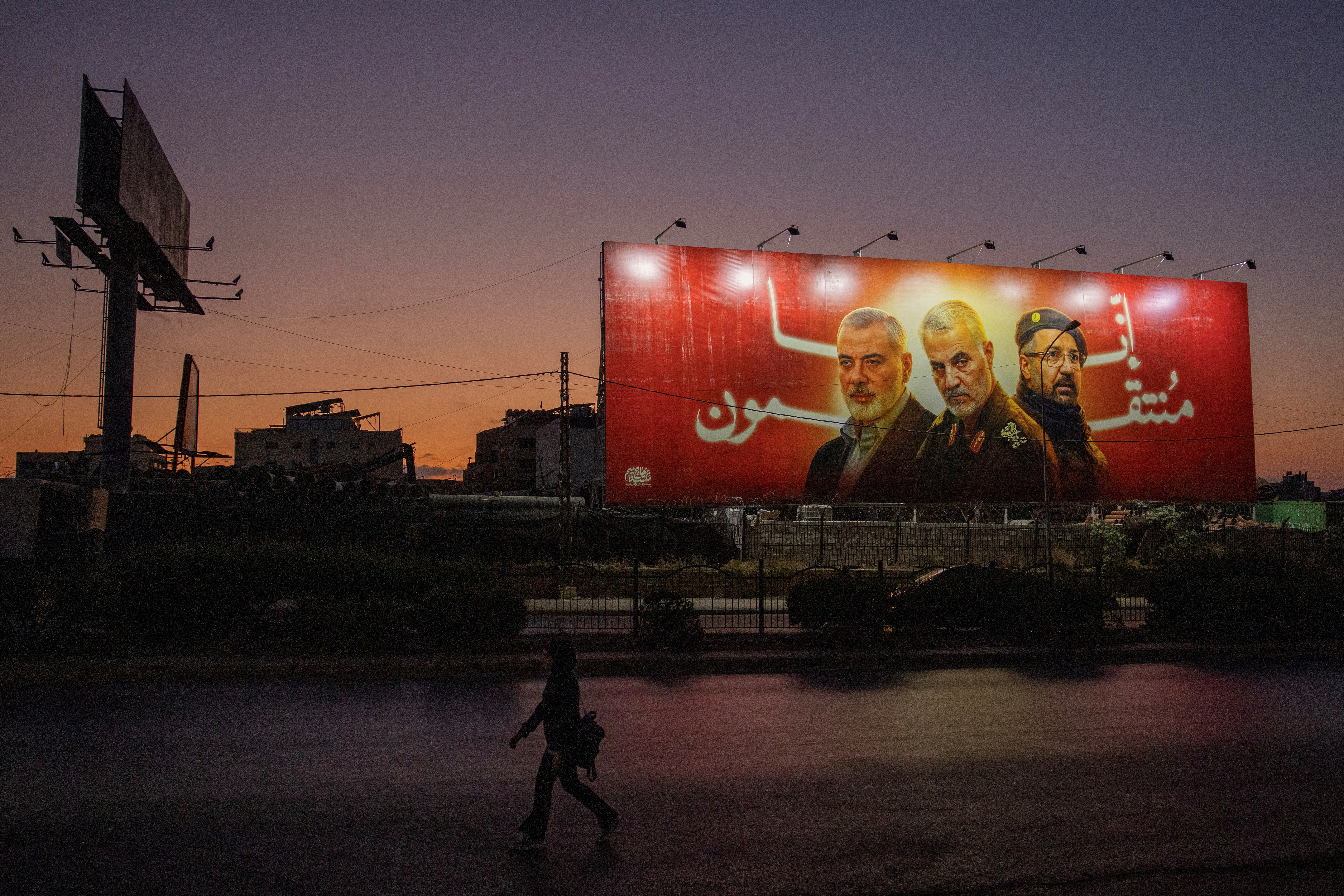 A poster depicts late Hamas leader Ismail Haniyeh, top commander of Iran's Quds Force Qassem Soleimani and Hezbollah top commander Fuad Shukr in Beirut