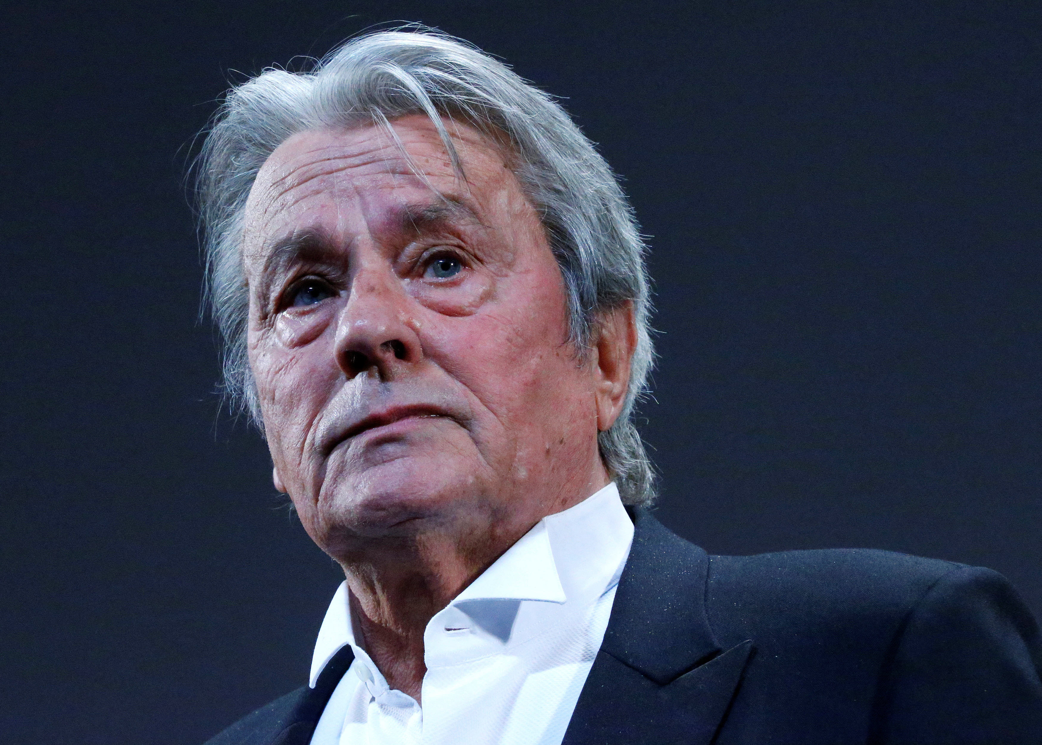 FILE PHOTO: Actor Alain Delon salutes on stage during a tribute for his career before the screening of the restored print of the film "Plein Soleil" by Rene Clement during the 66th Cannes Film Festival