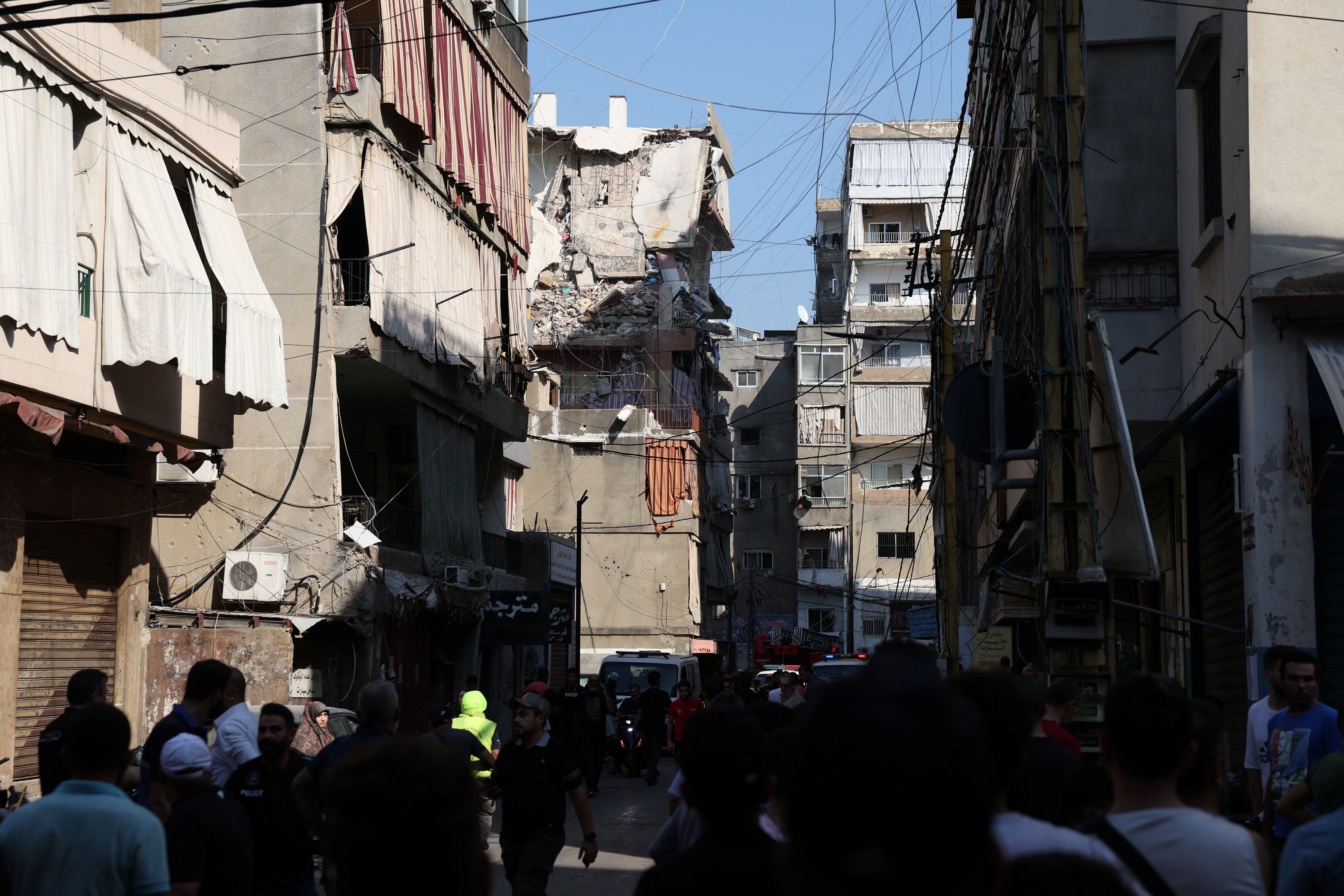 People gather near the site of an Israeli strike in Beirut's southern suburbs