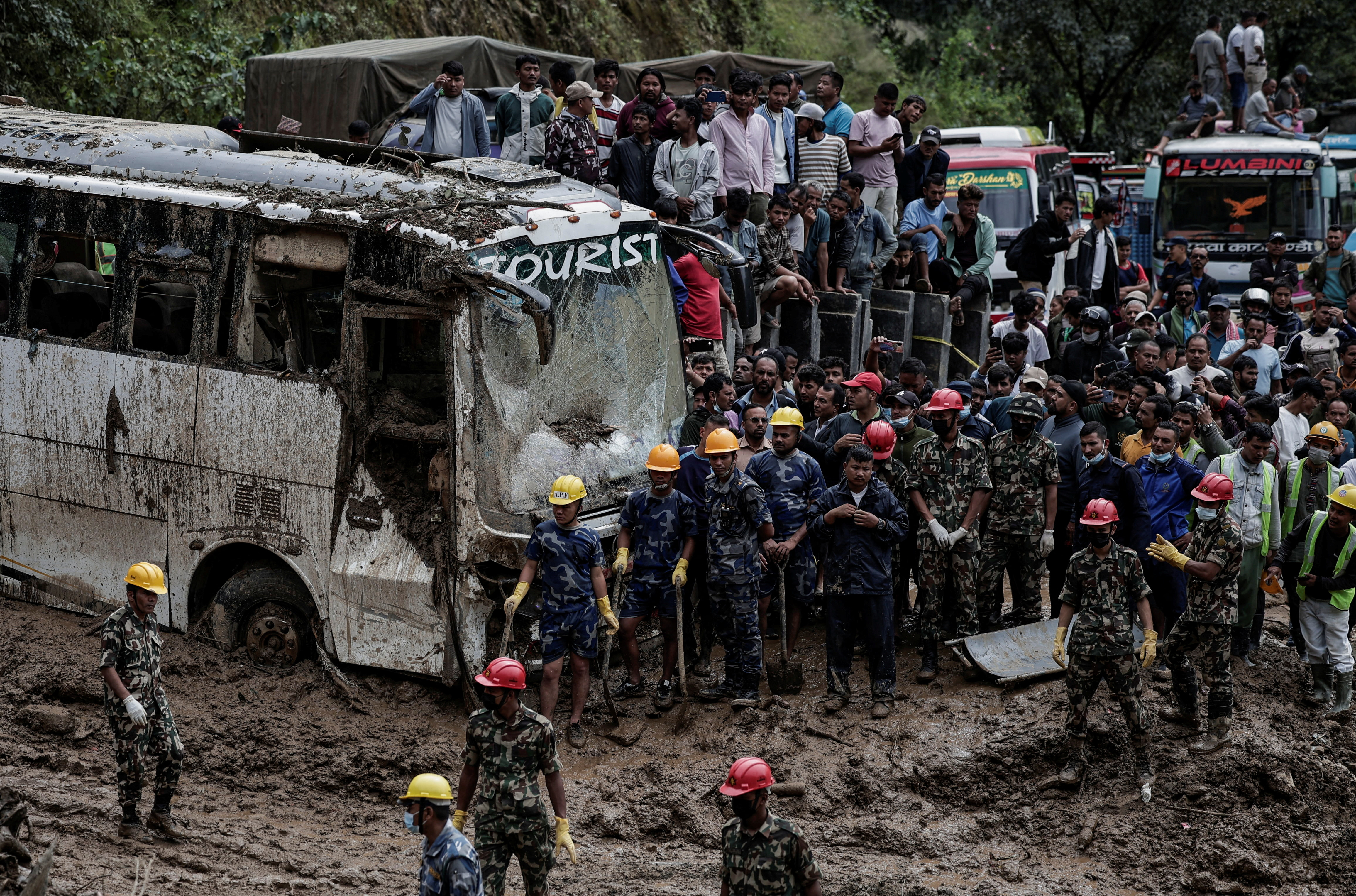 Rescue personnel work to retrieve the bodies of the victims from a landslide triggered by heavy rainfall in Dhading