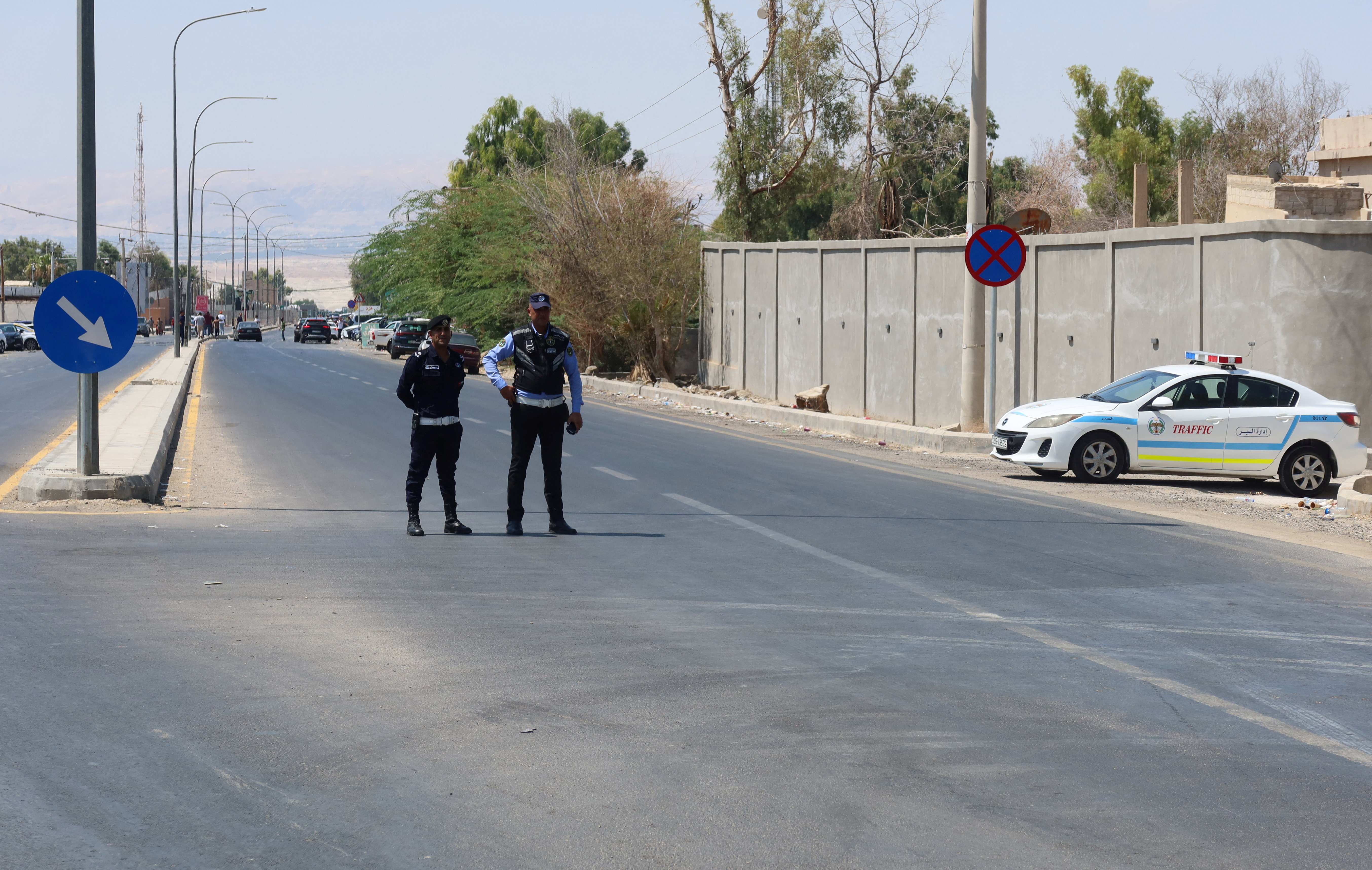 Police members man a checkpoint near King Hussein Bridge crossing