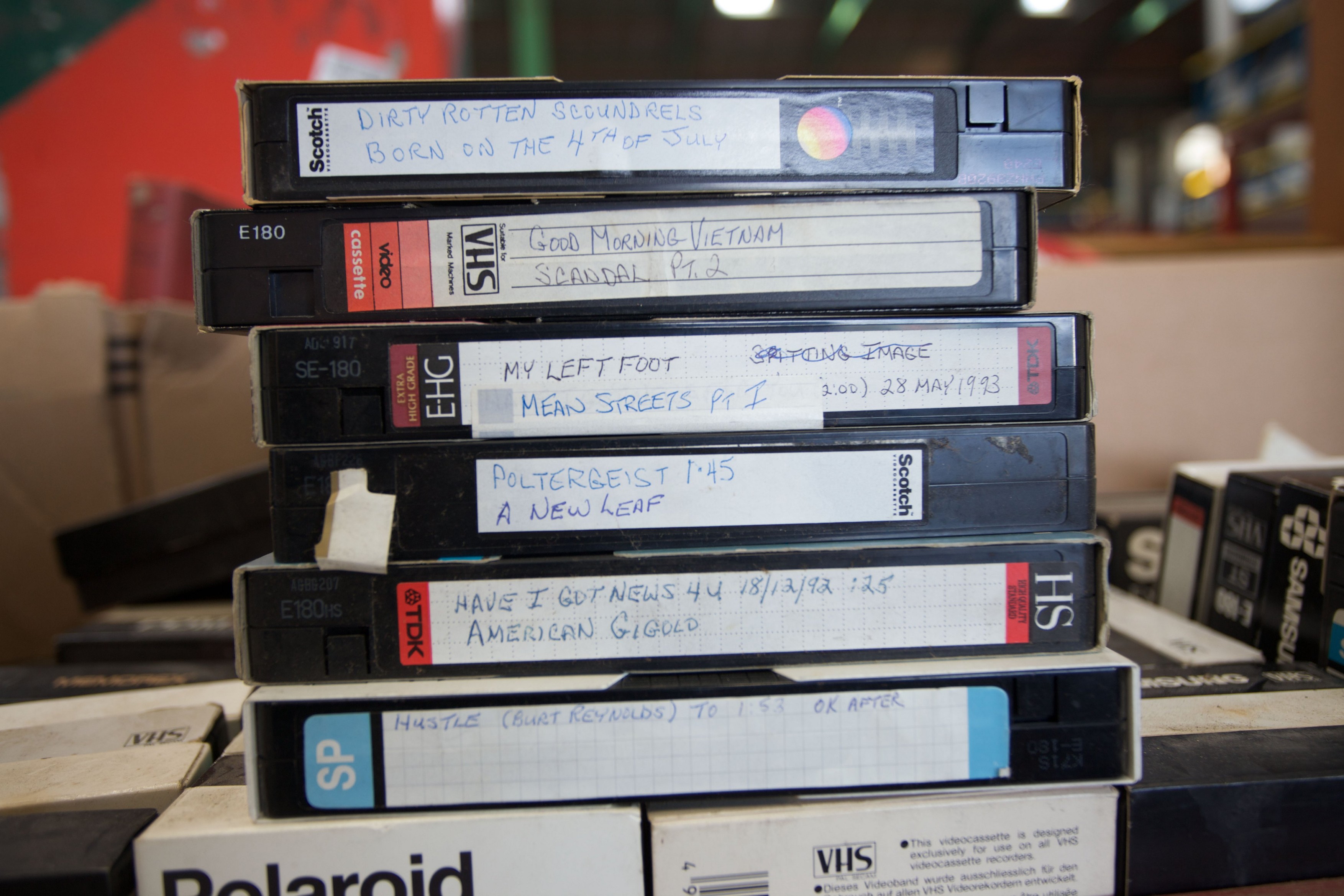 A pile of VHS video cassettes on sale at a flea market.