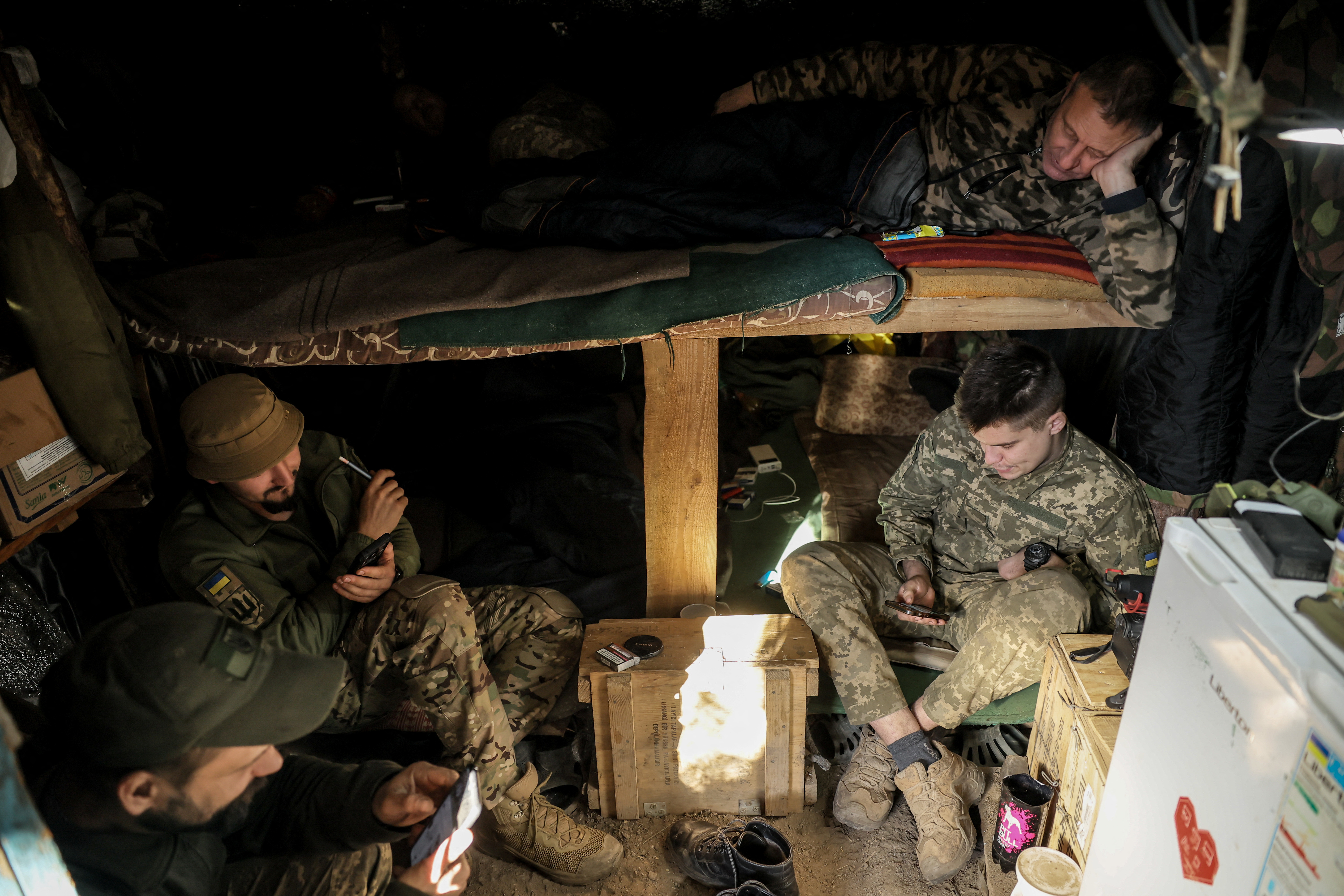 Ukrainian servicemen rest in a dugout at a frontline near the town of Chasiv Yar