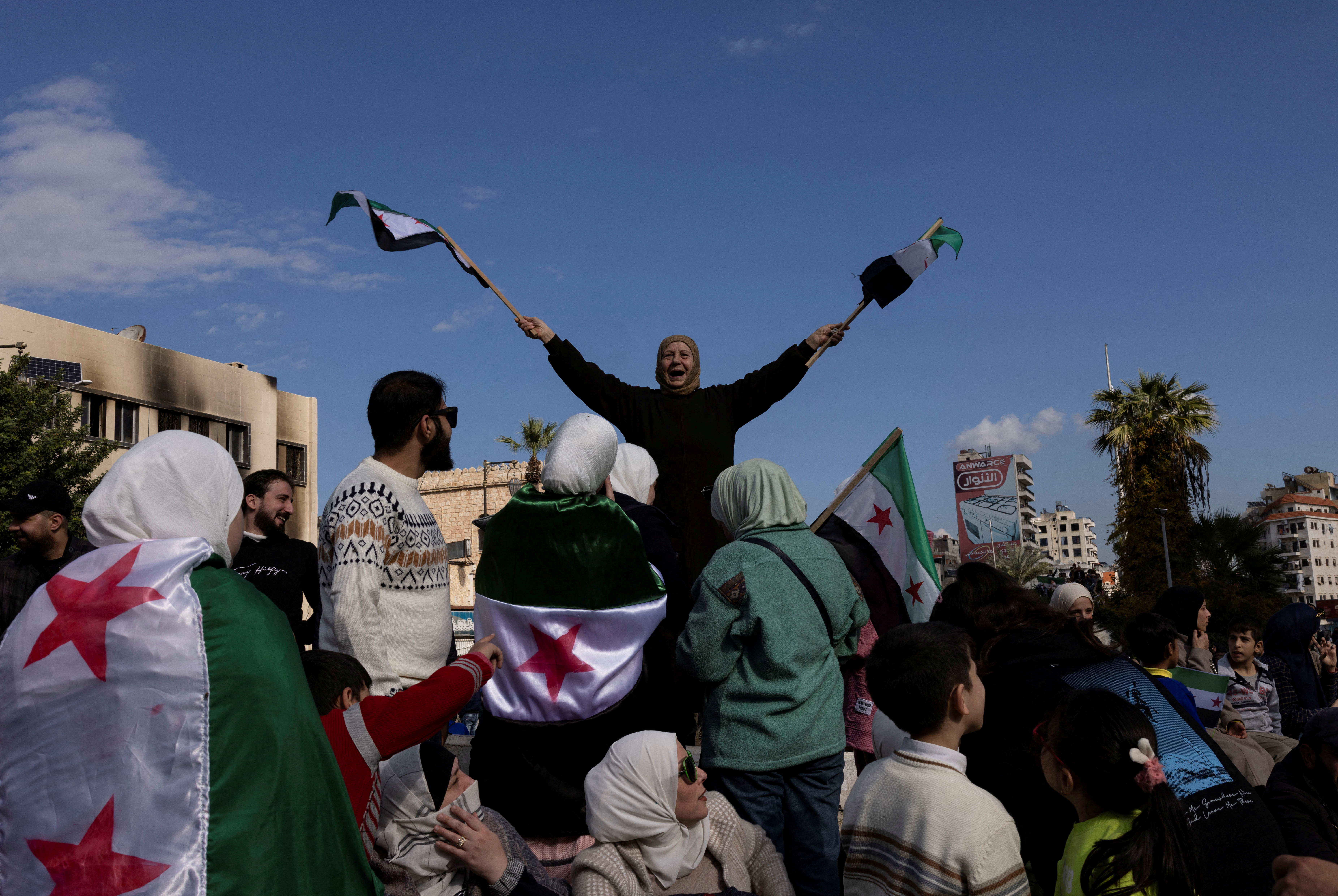 People celebrate after ousting of Syria's Bashar al-Assad during a gathering after friday prayers in Latakia