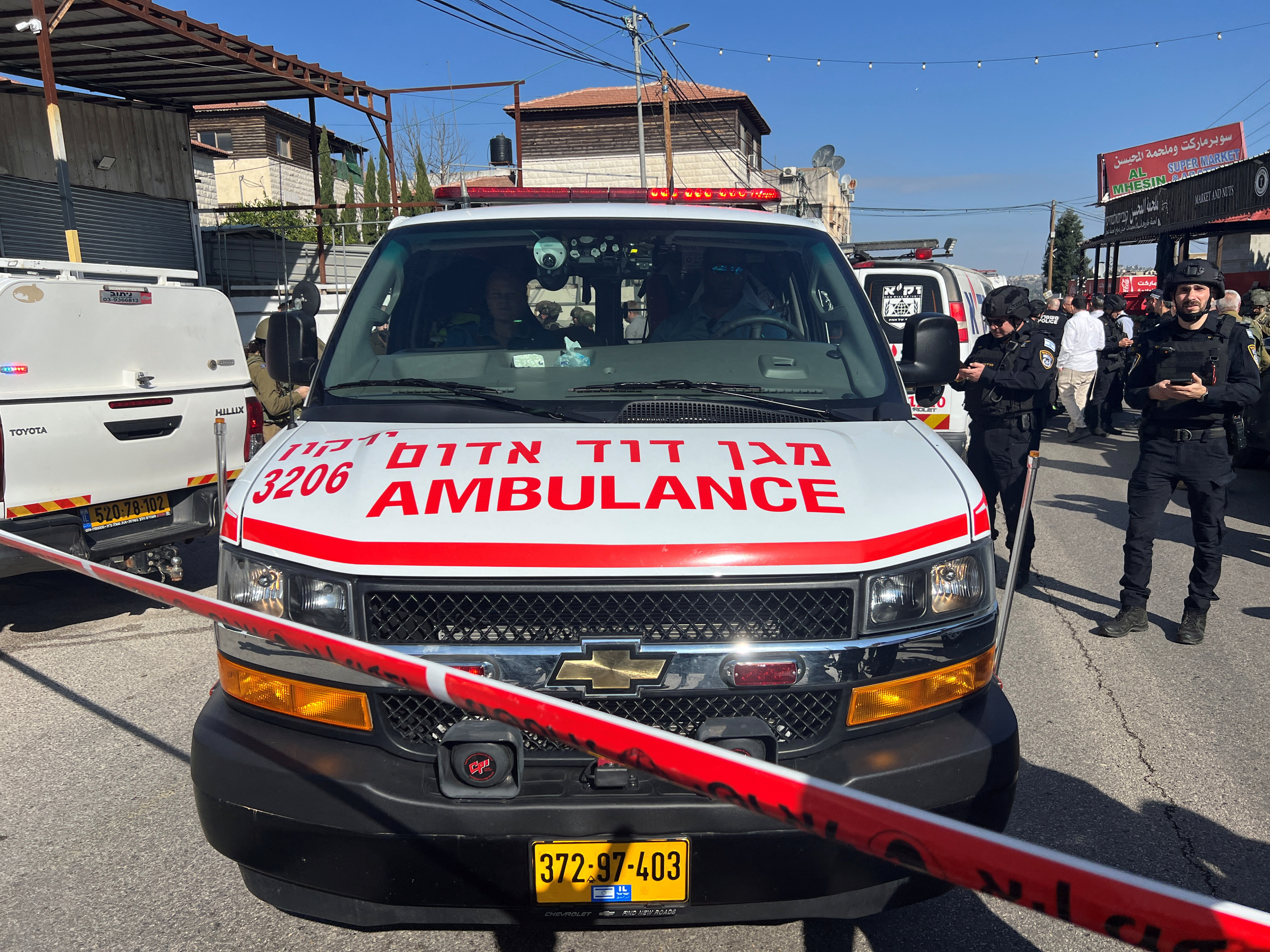 Israeli security and rescue personnel at the scene of a shooting attack on a car and bus where at least three Israelis were killed near Kedumim in the Israeli-occupied West Bank