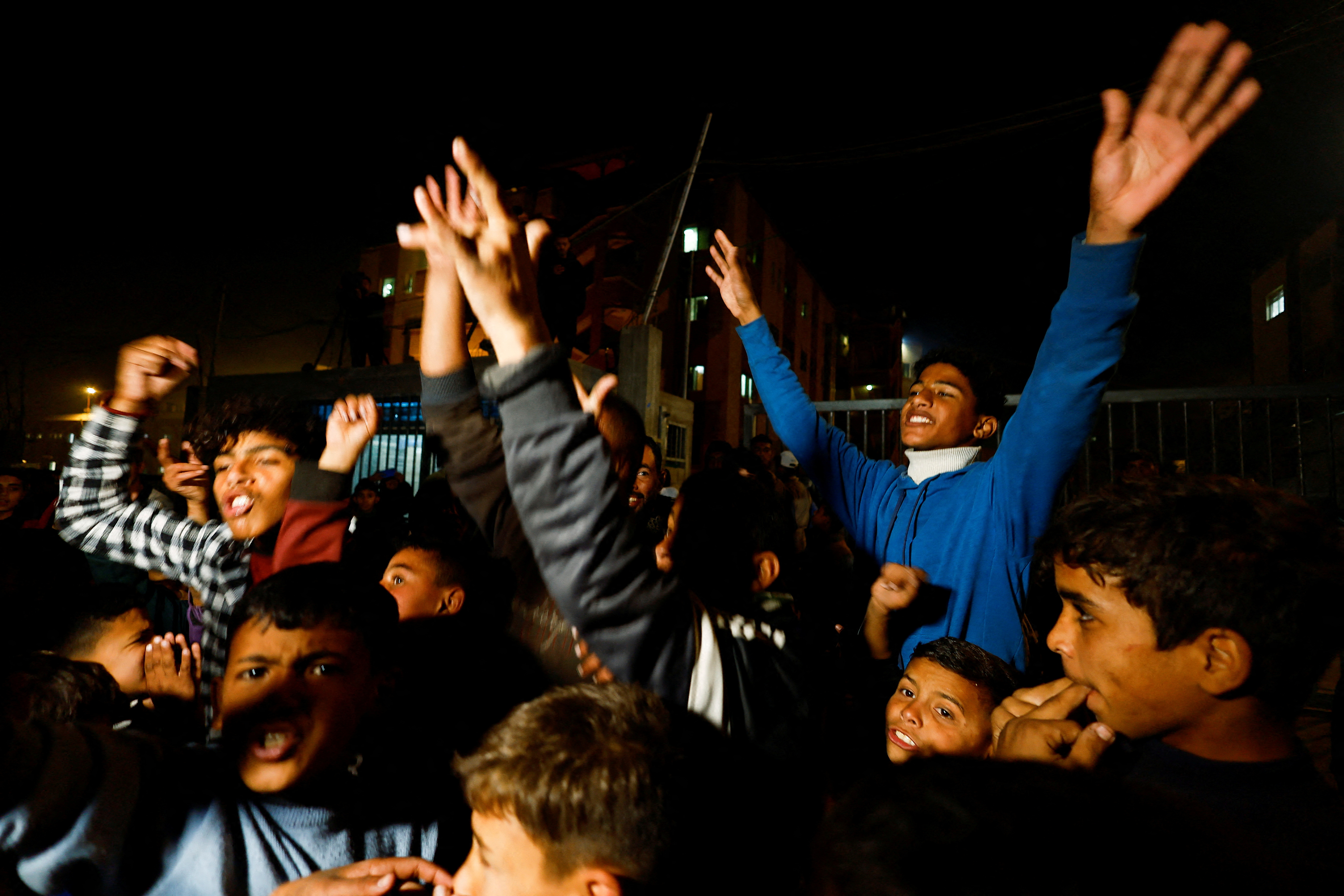 Palestinians react as they wait for news of a ceasefire deal with Israel, in Khan Younis in the southern Gaza Strip