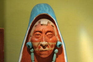 1737119902-A-clay-sculptor-painted-in-Maya-Blue-made-by-Luis-May-Ku-49-of-a-hooded-elderly-woman-from-his-community-of-Dzan-Yucatan-Mexico-taken-on-9-September-2024-300x200.jpg