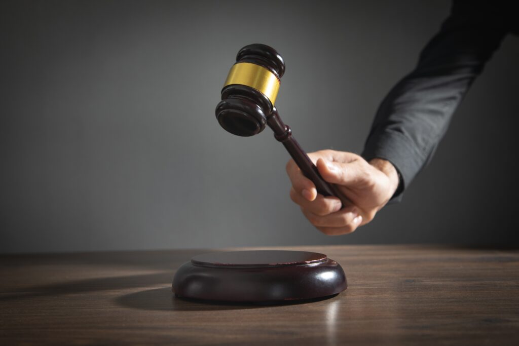 Male,Judge,In,A,Courtroom,Striking,The,Gavel.