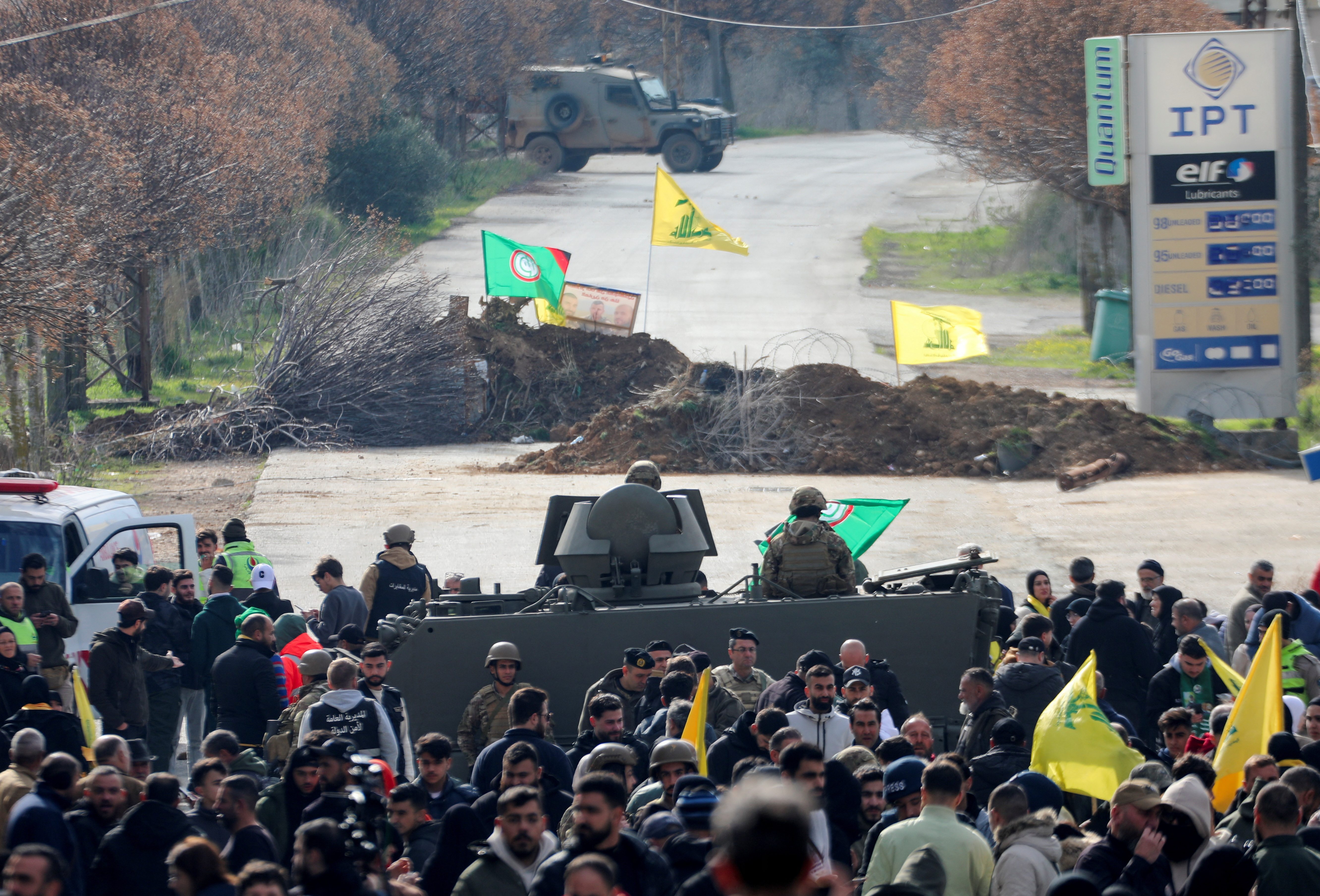 Locals hold Hezbollah flags as they gather in Burj al-Muluk, near the southern Lebanese village of Kfar Kila