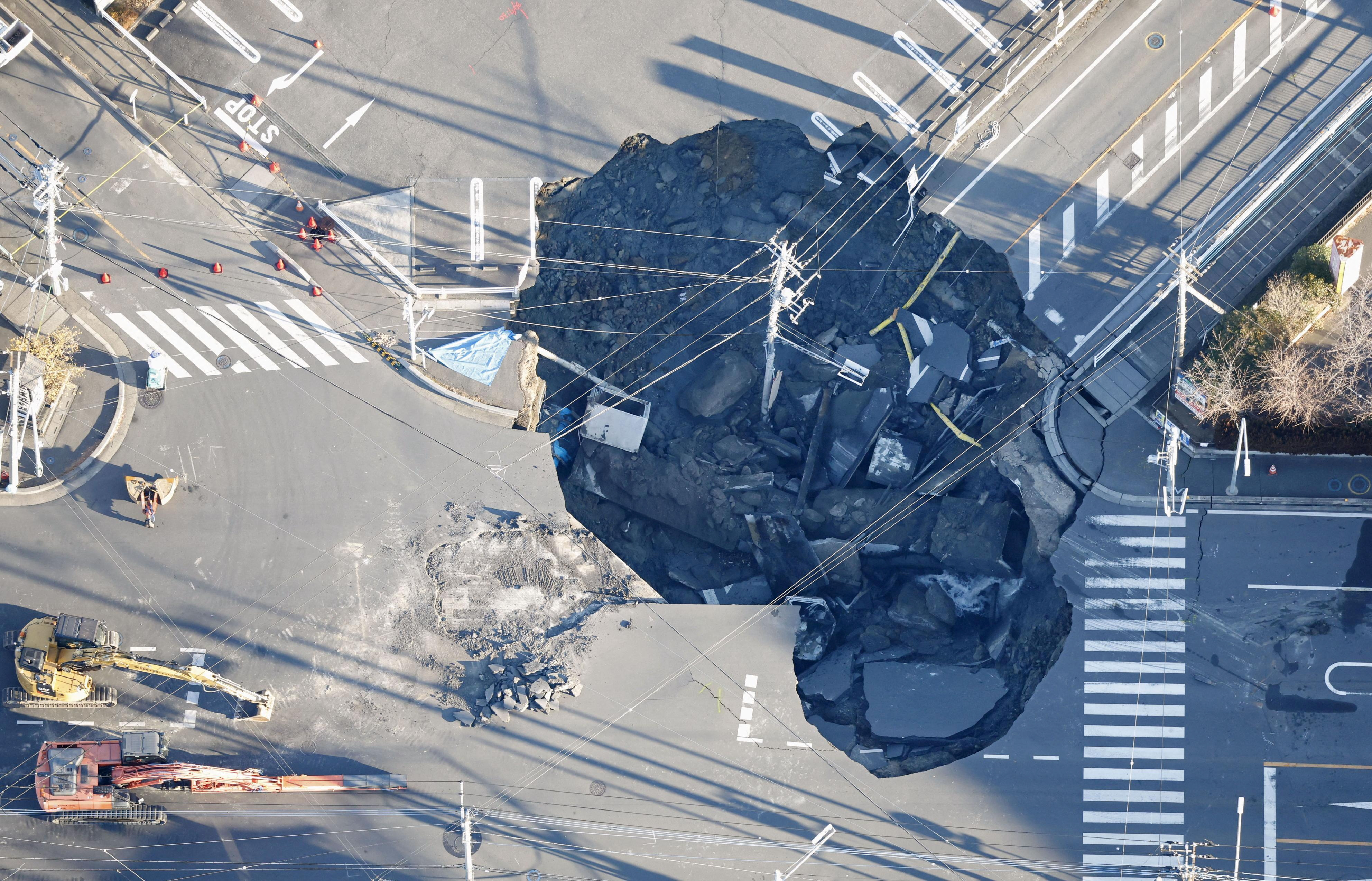 An aerial view shows a large sinkhole at an intersection in Yashio