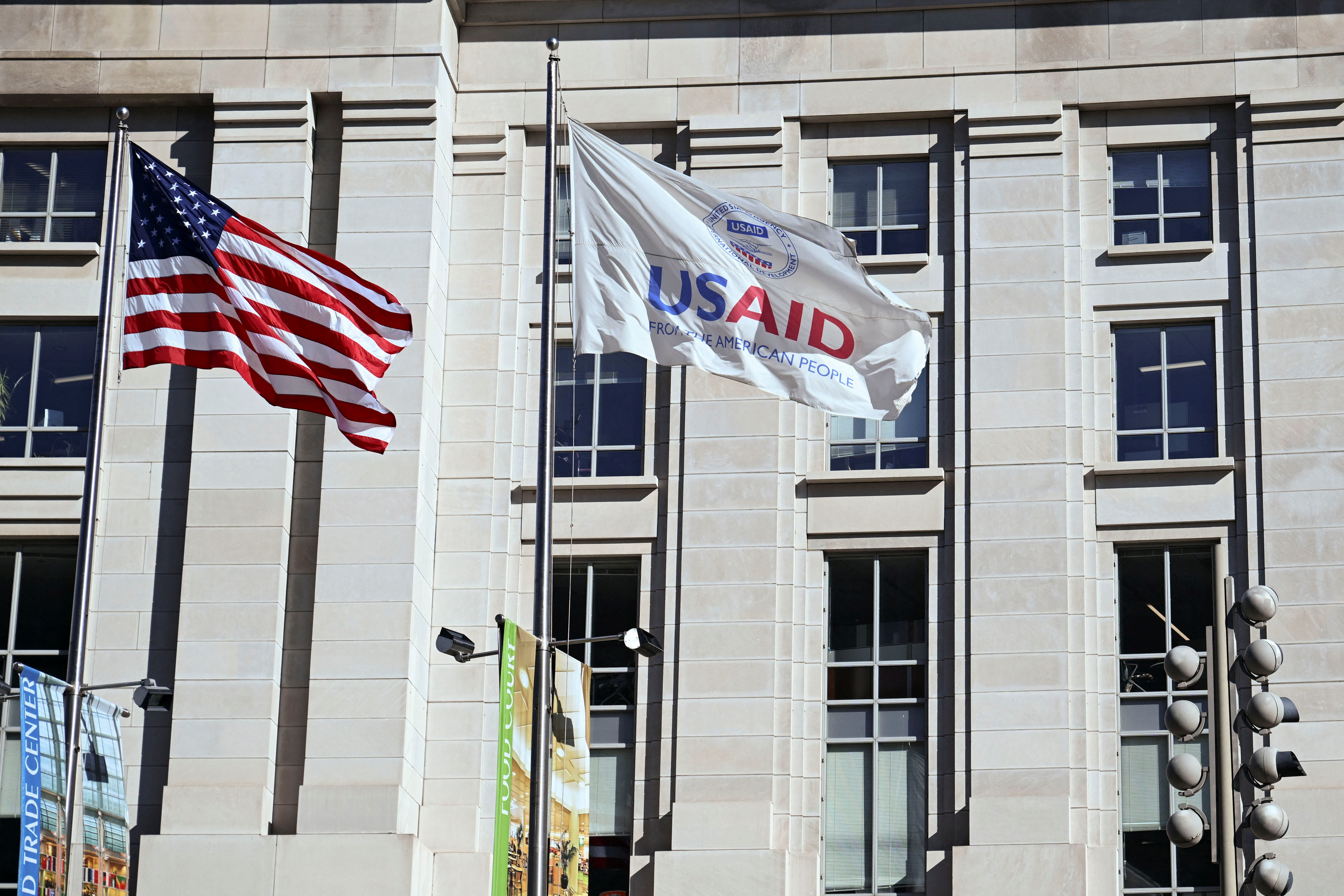 An American flag and USAID flag fly outside the USAID building in Washington