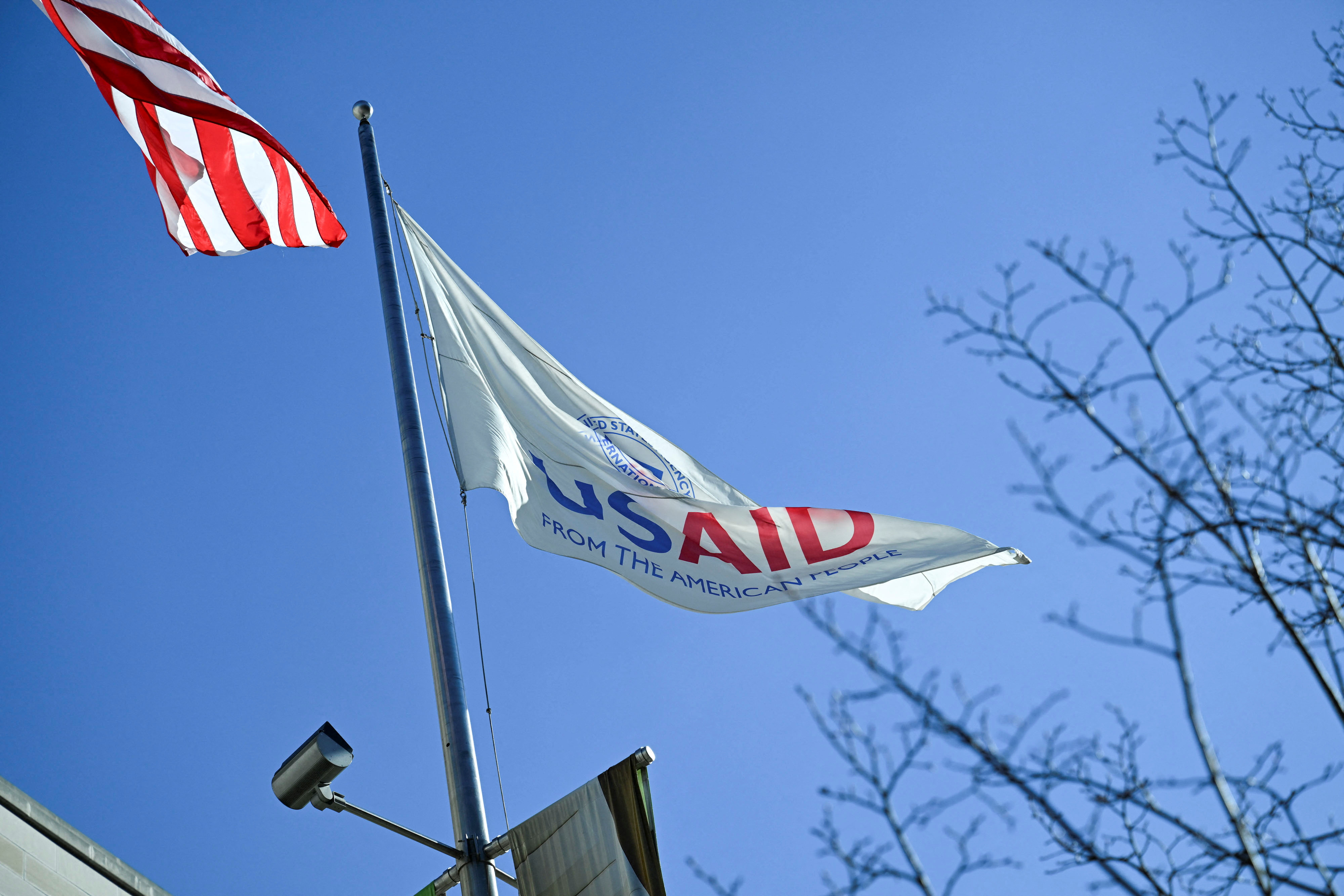 An American flag and USAID flag fly outside the USAID building in Washington