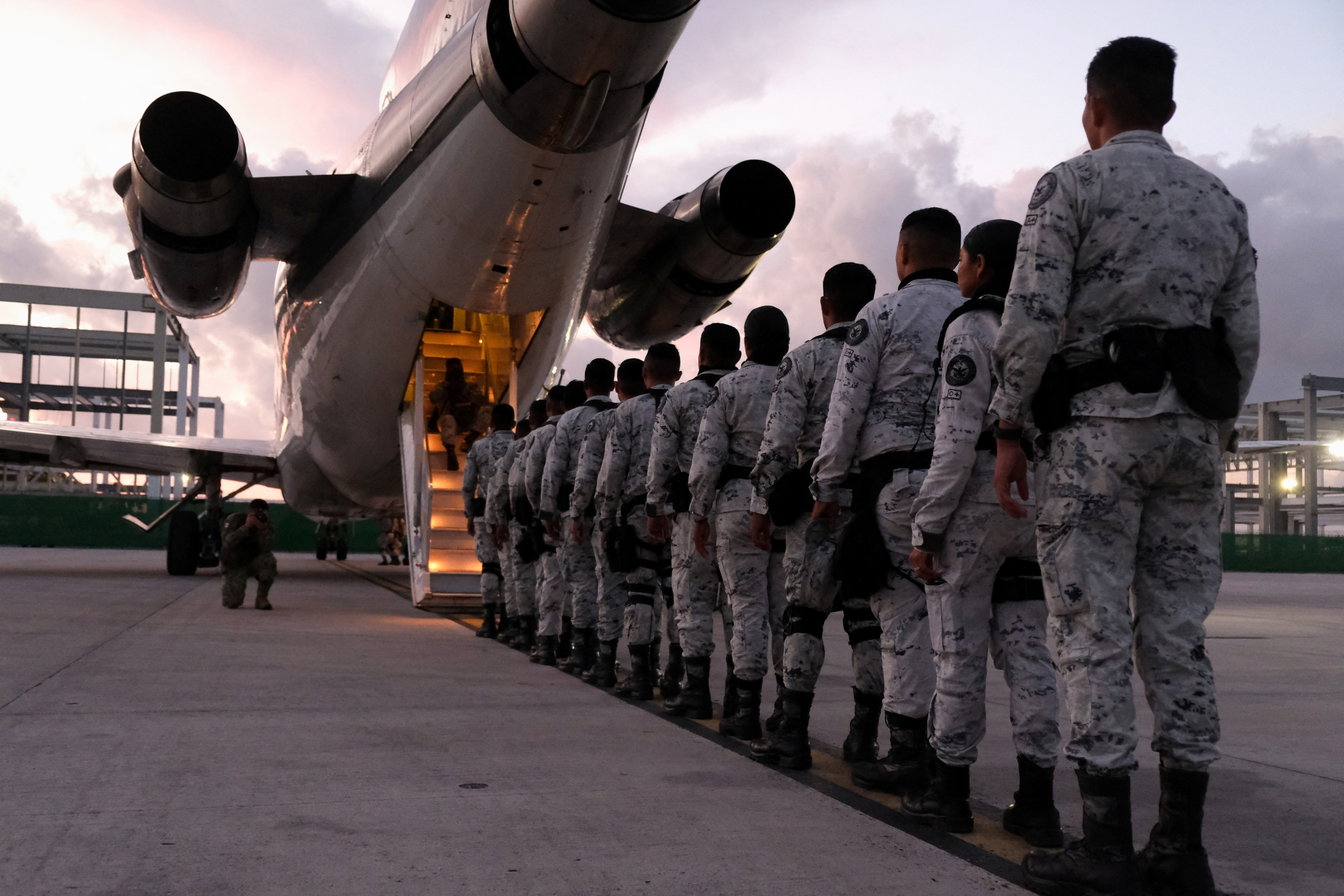 Members of Mexico's National Guard board a plane bound for the northern border, in Cancun