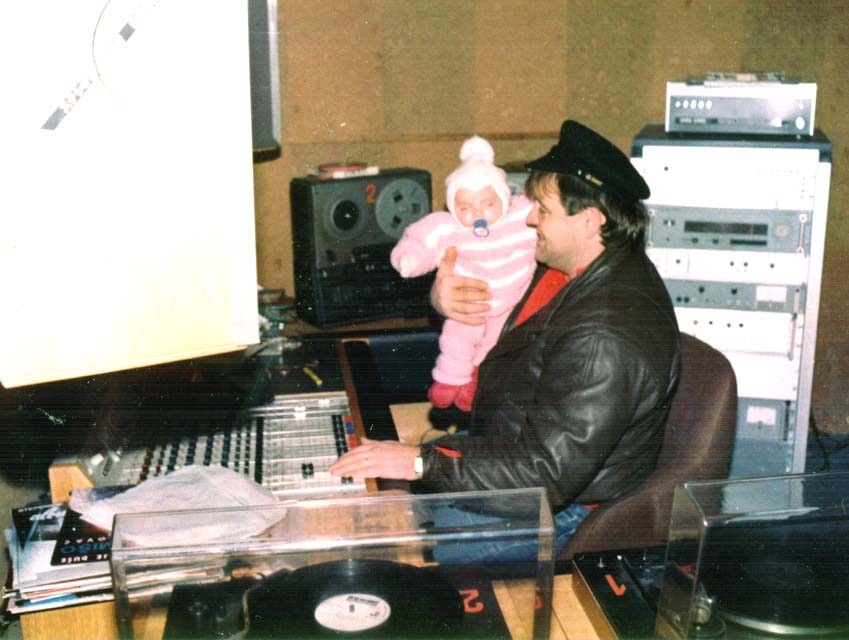 Marinko Sekulić u prostorijama Radija Srebrenica sa kćerkom u naručju koja danas također radi u medijima