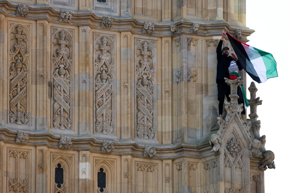 A man holding a Palestinian flag climbs Big Ben in London